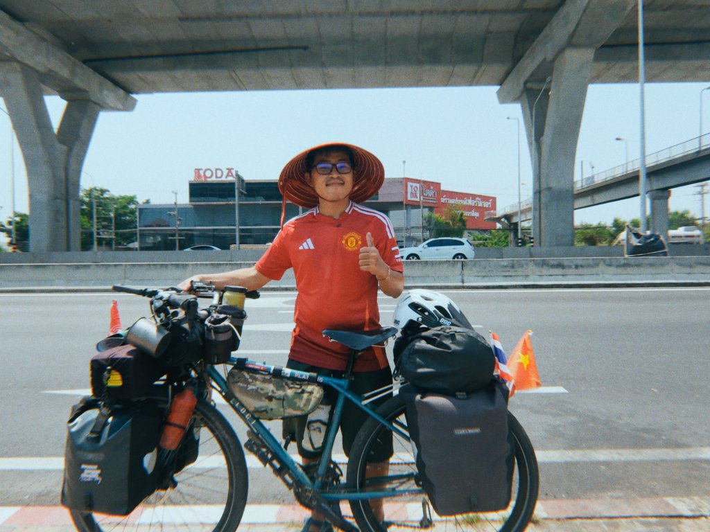 Gom giving thumbs up in Thailand with his loaded bicycle