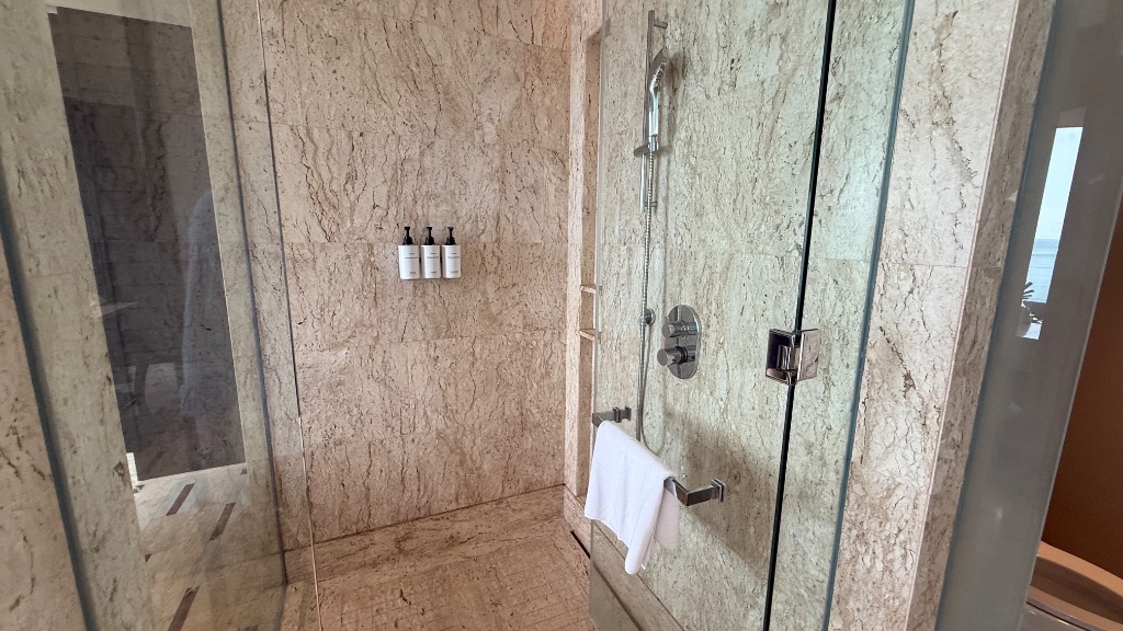 Walk-in shower - full travertine surround, rainfall and handheld