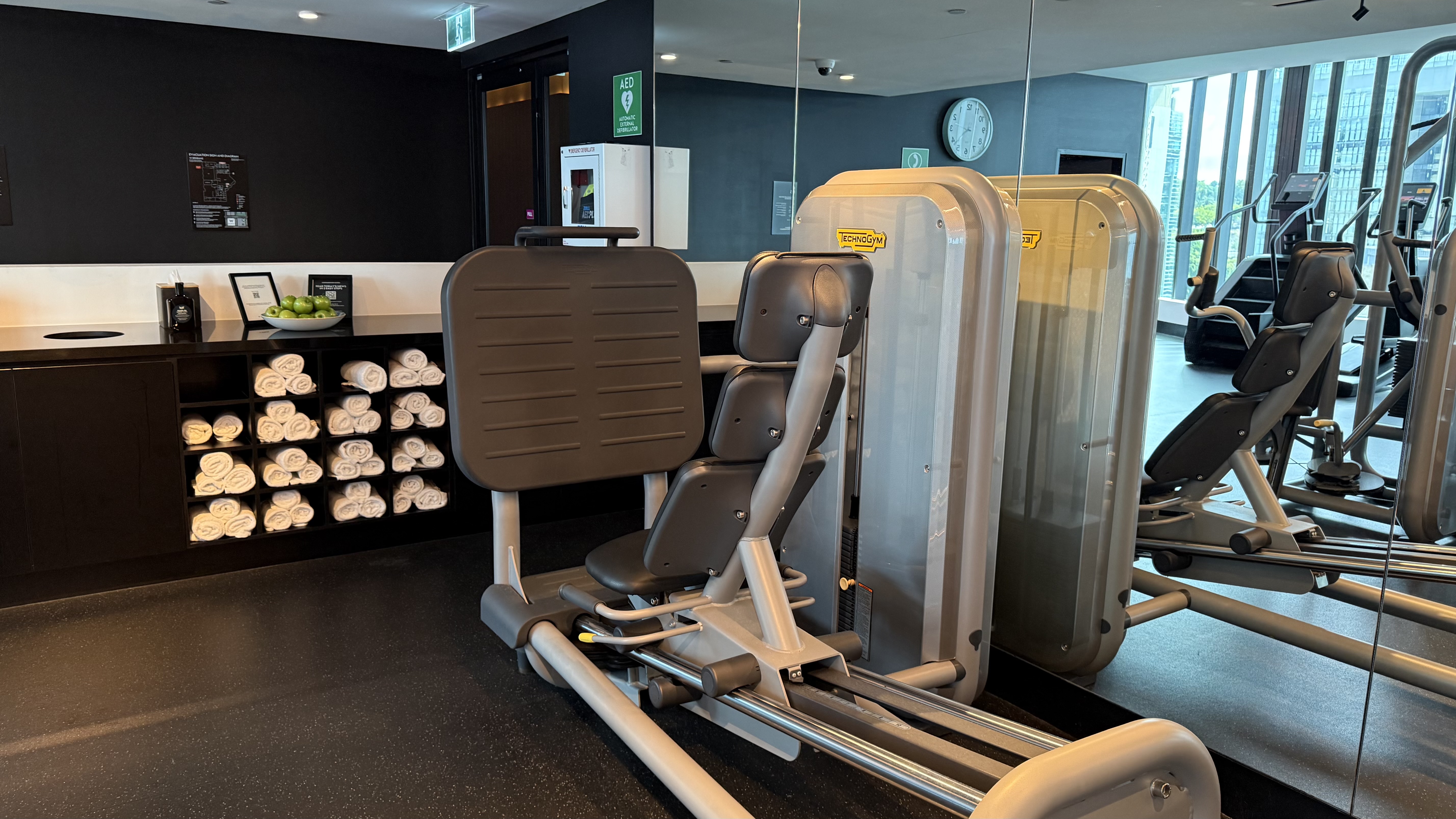FIT gym — Technogym resistance machines, rolled towels and city views
