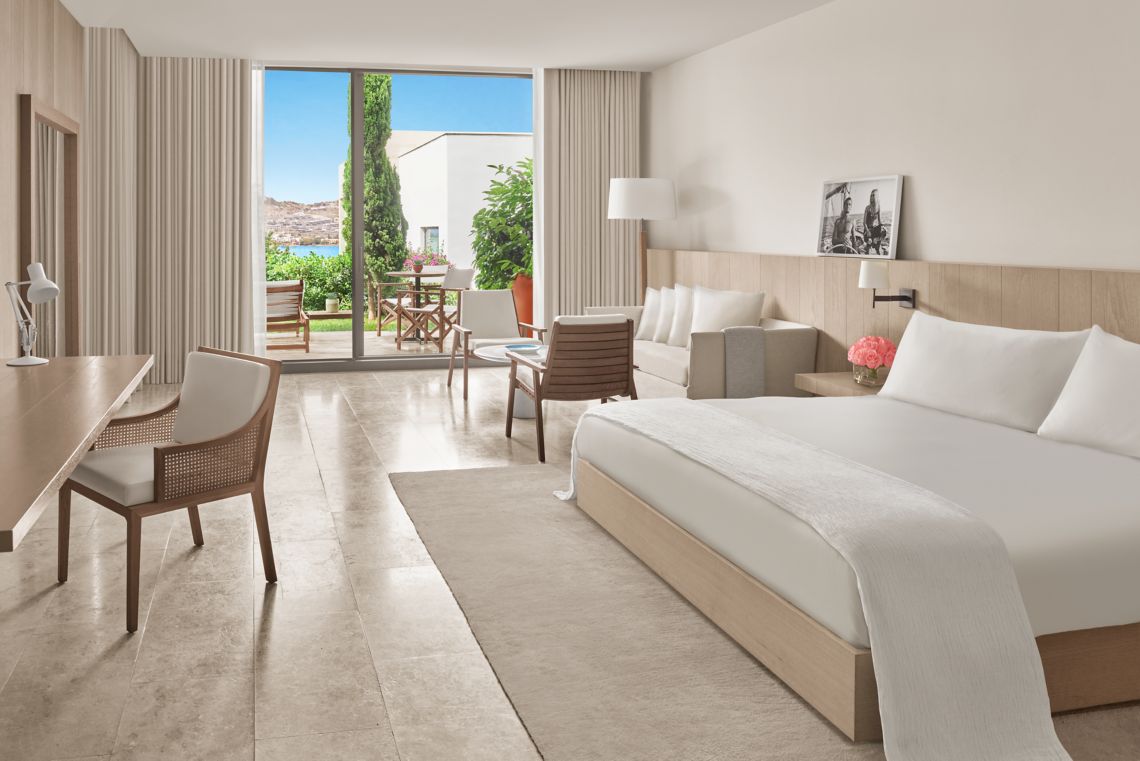 Loft Garden View Room — spacious layout with sitting area, garden view and clean travertine finishes