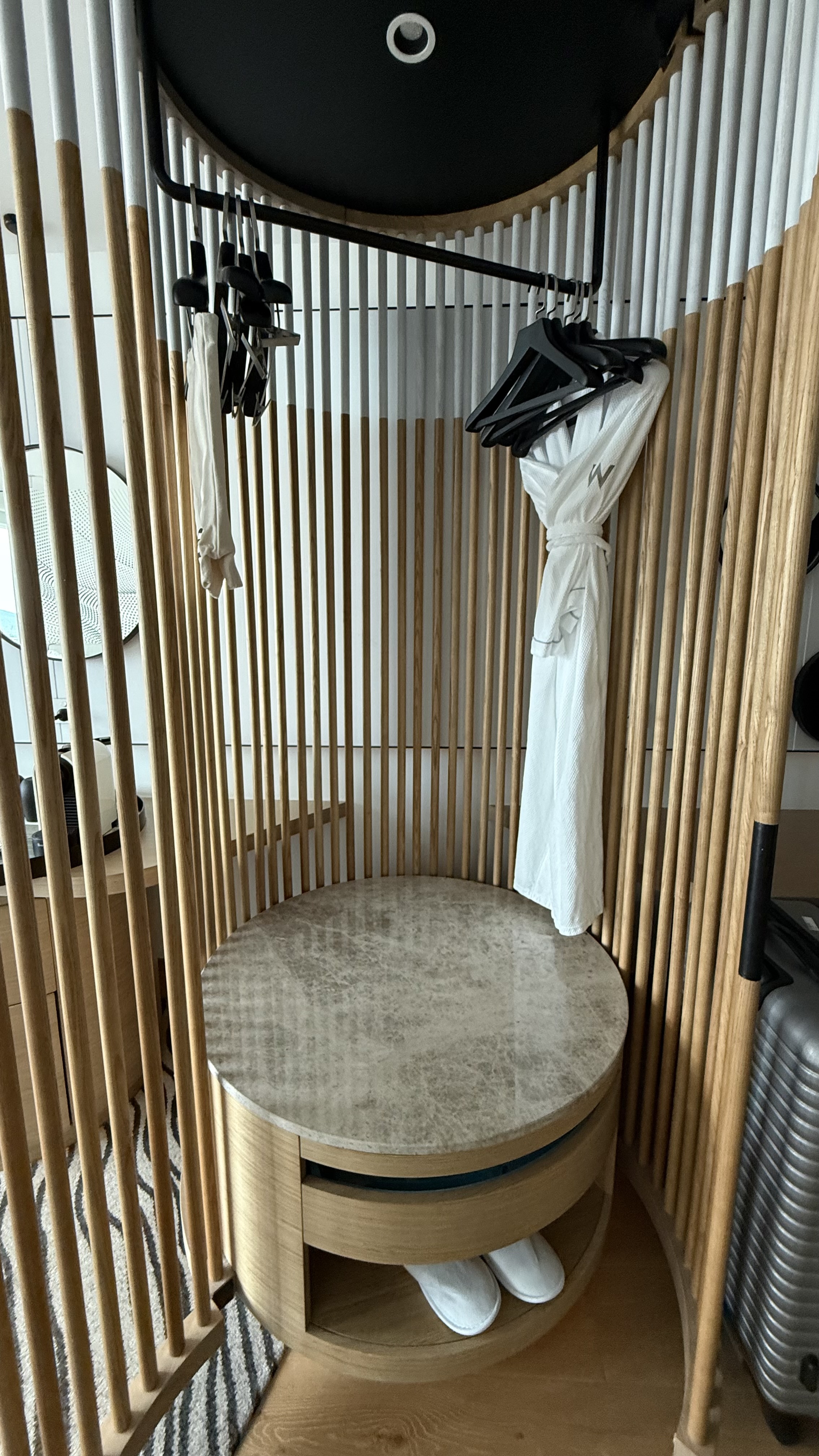 The wardrobe — circular slatted timber design with W robes and slippers