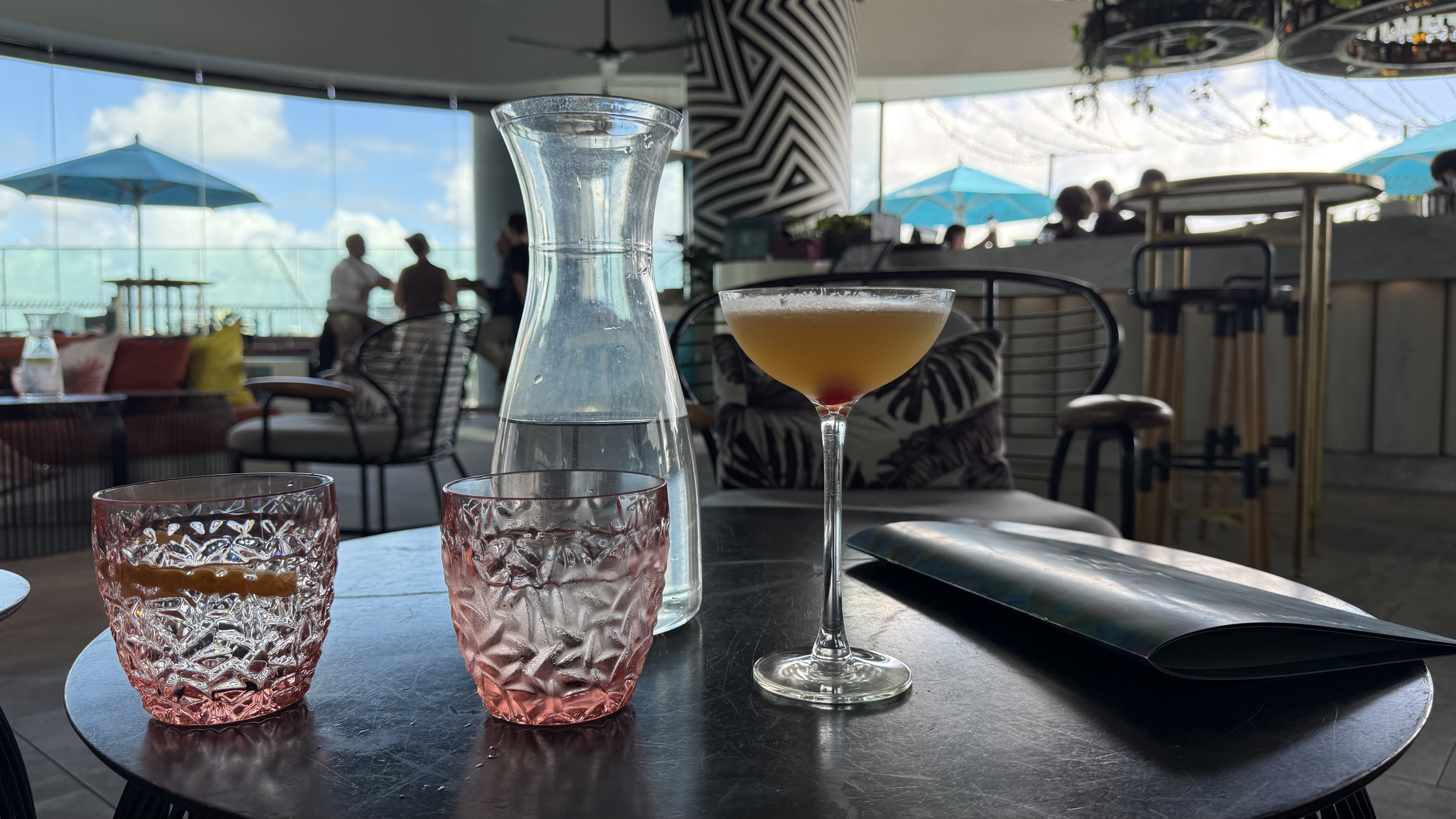 Cocktails at the WET Deck bar — a daiquiri, carafe of water and the pool terrace behind