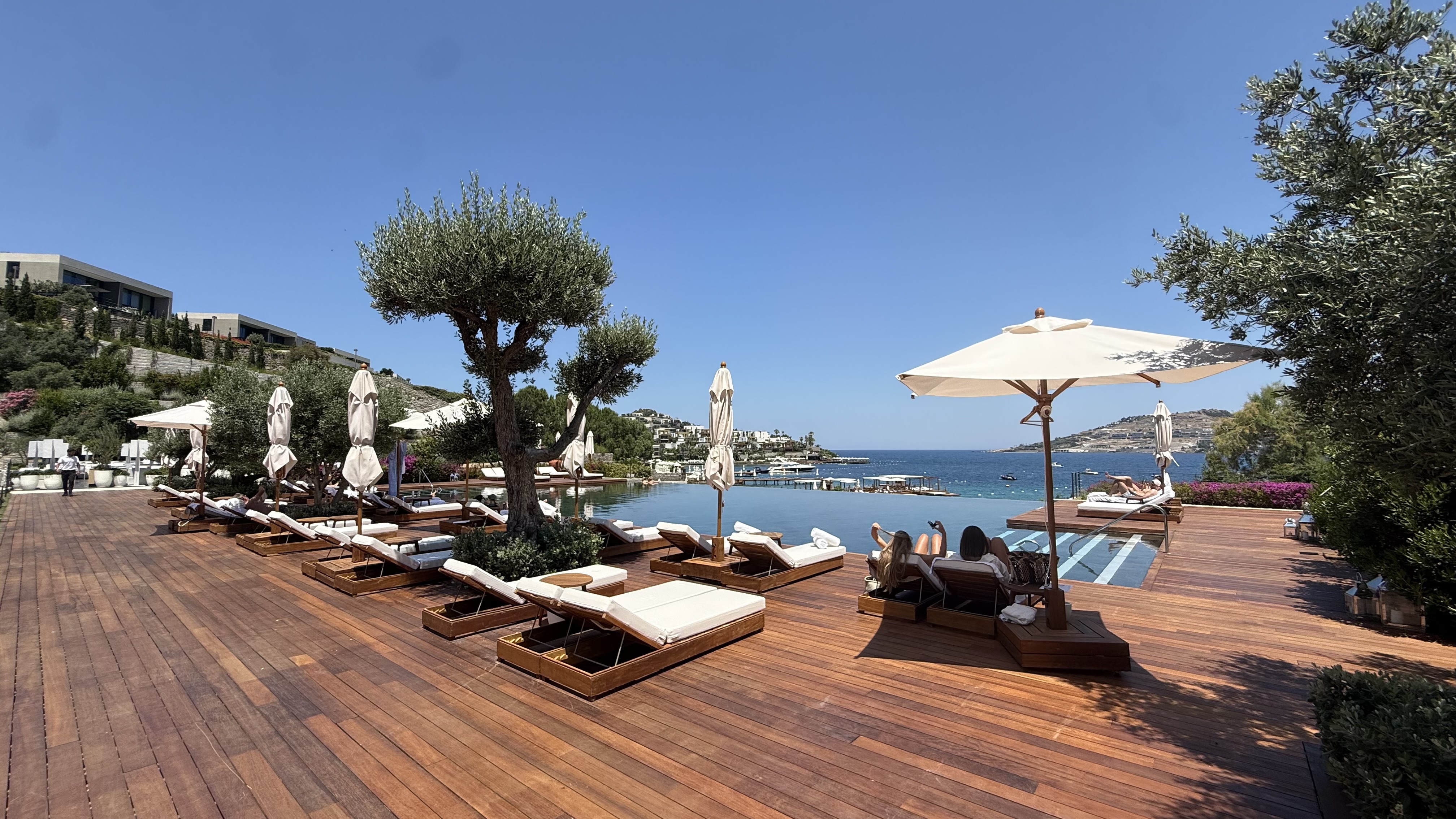 Pool deck — the full sweep of the infinity edge looking out to the Aegean