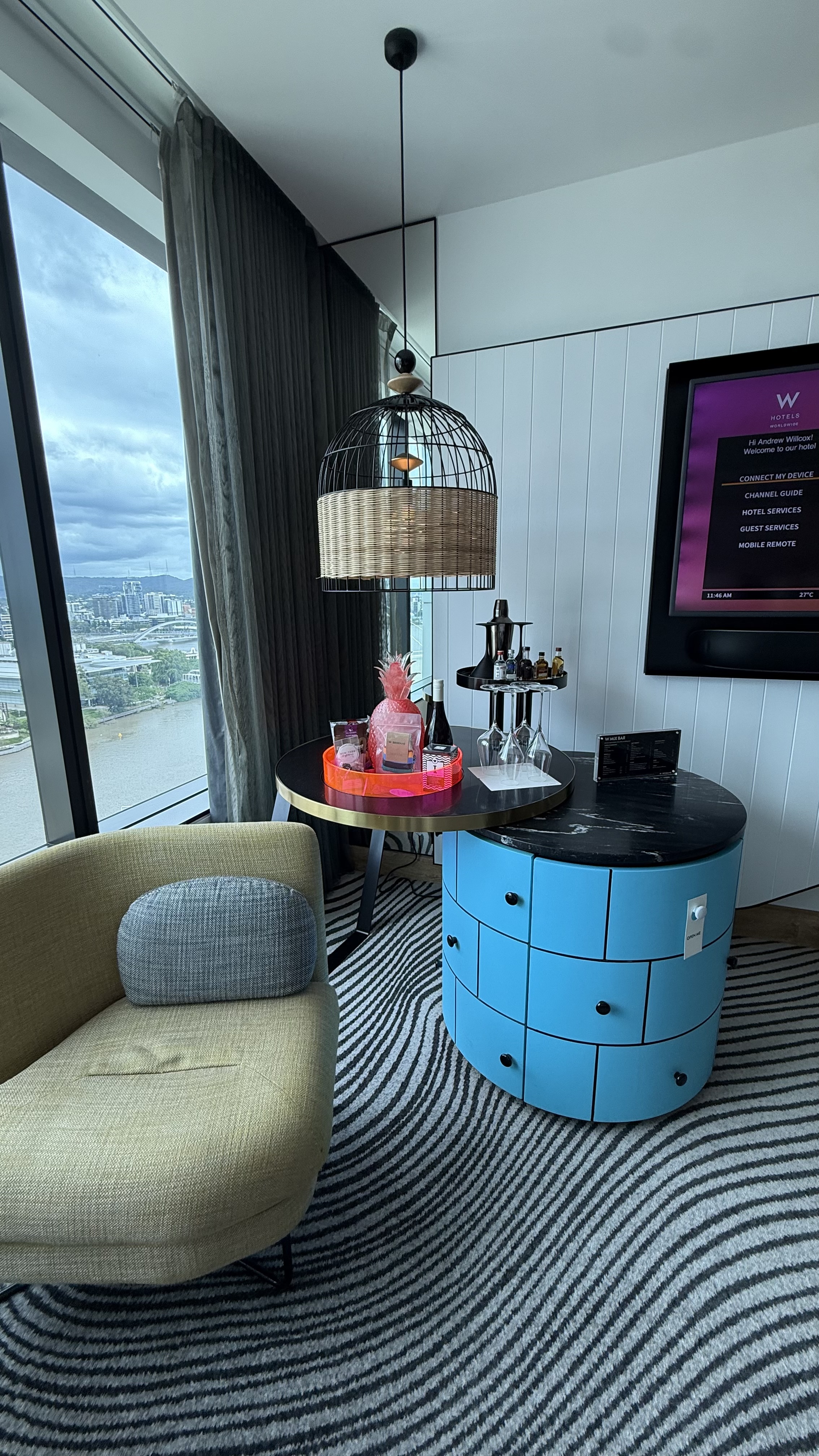 Room sitting area — birdcage pendant lamp, blue circular cabinet and Brisbane River views