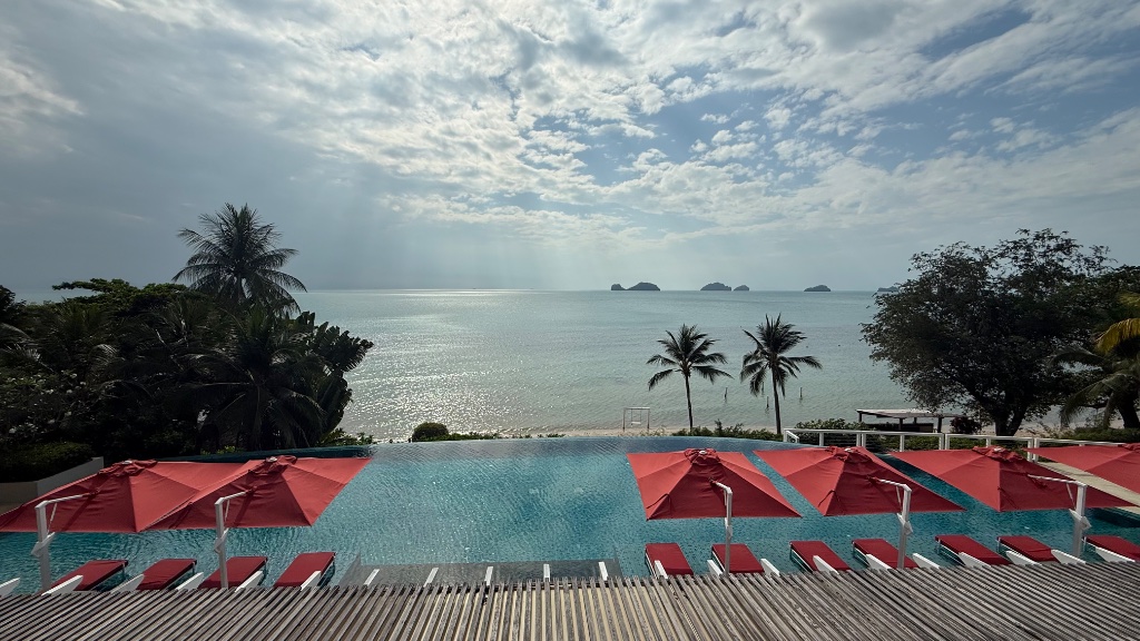 Pool area - red cabanas, pool, and the Gulf stretching to the horizon