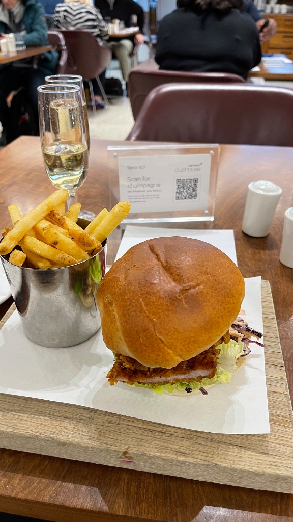 Chicken katsu burger with fries and champagne — à la carte dining in the lounge