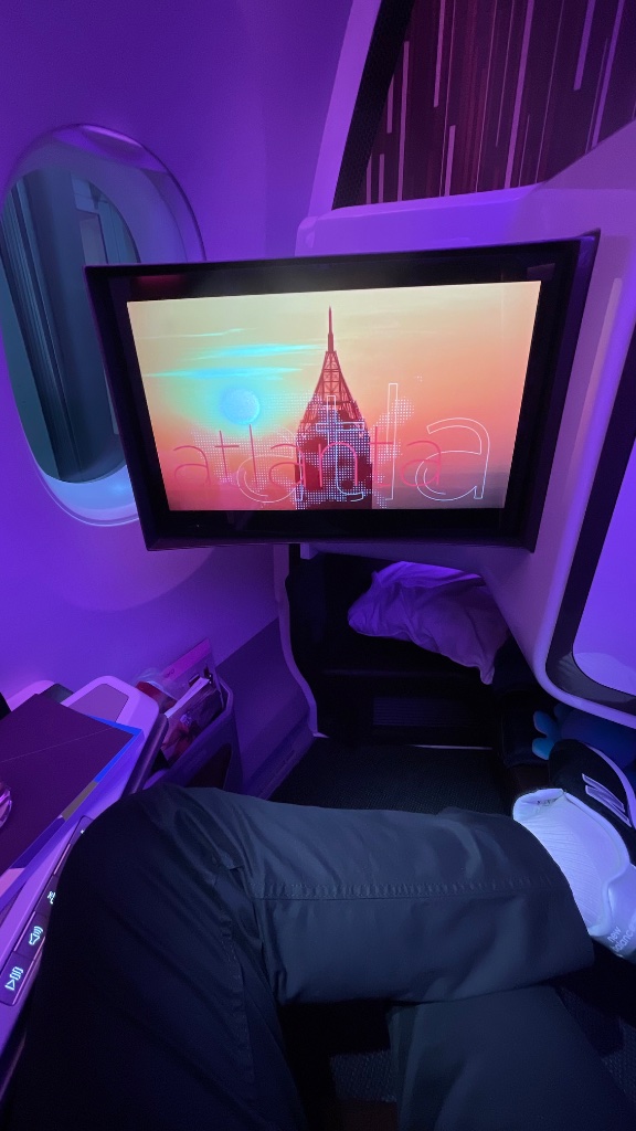 Seat 1A — Upper Class suite with the signature purple mood lighting