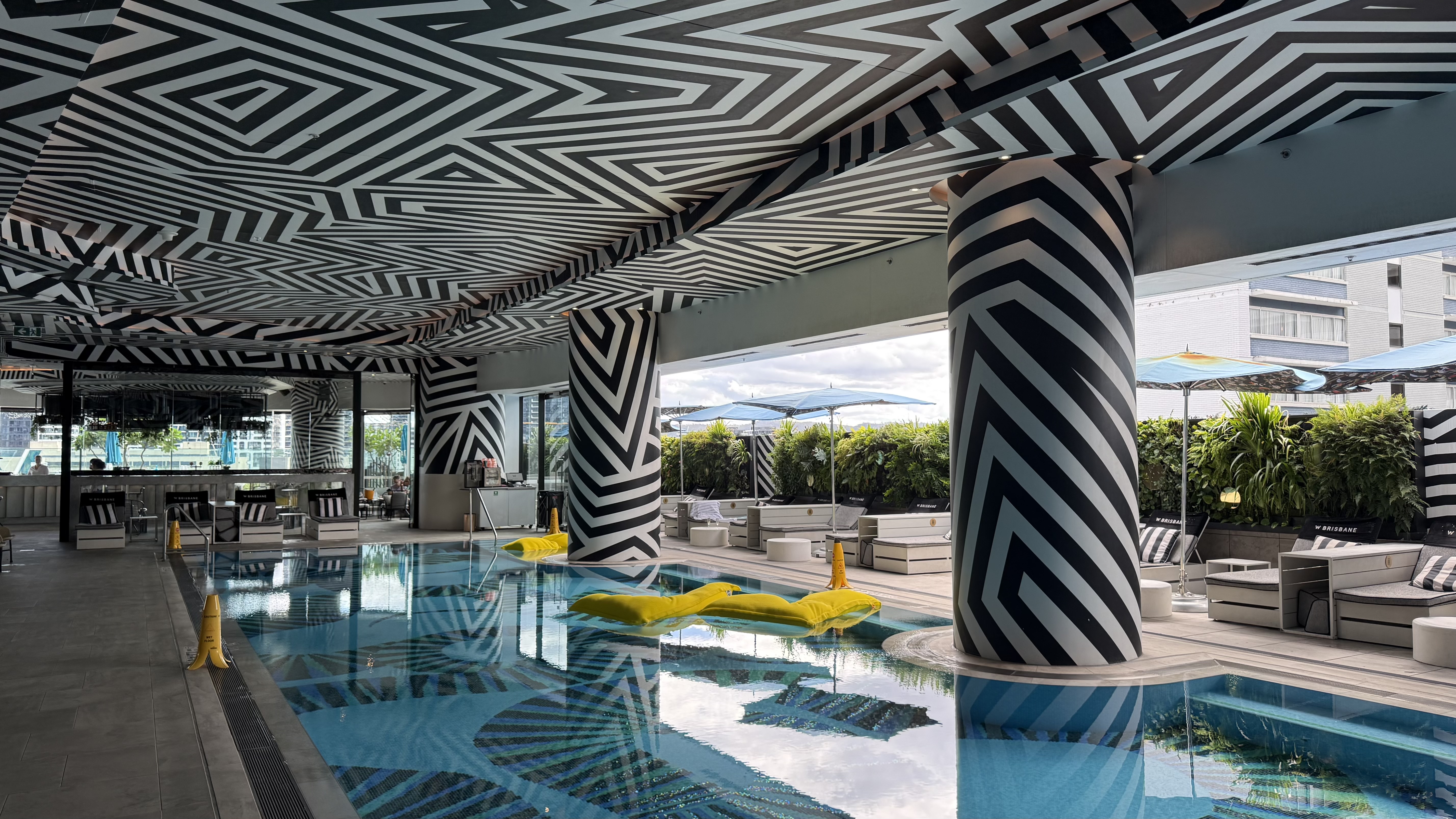 WET Deck wide — yellow pool floats, zigzag ceiling and the open terrace beyond