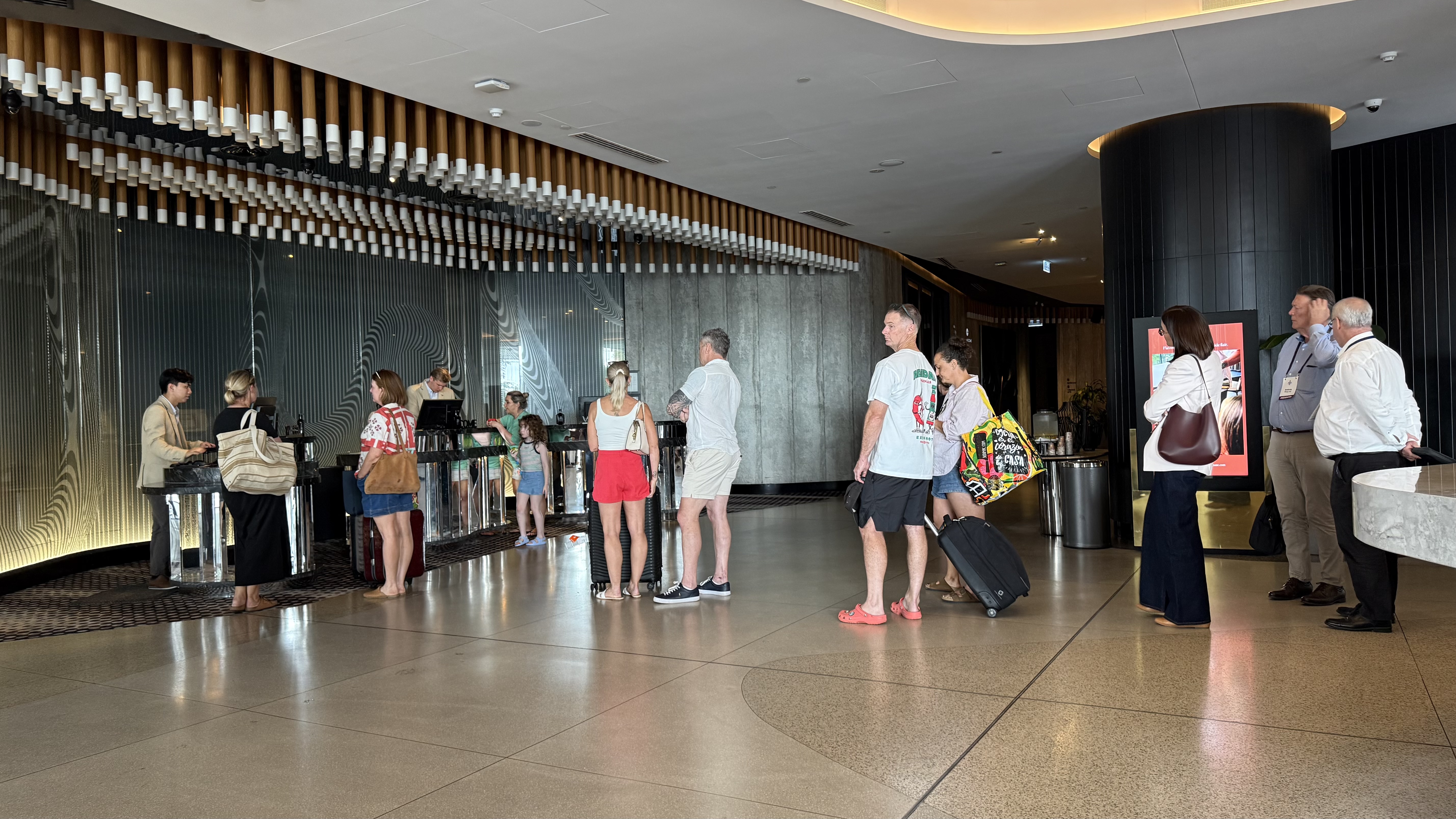 Peak check-in — queues at the desk, but the ceiling installation above is extraordinary