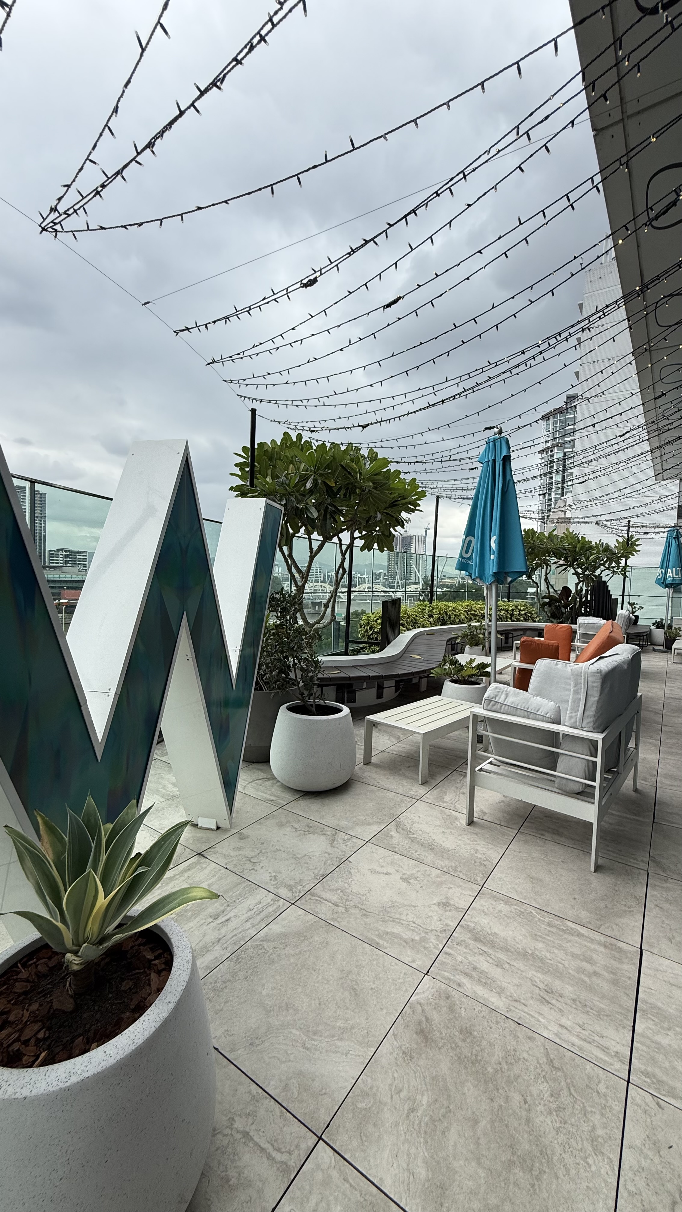 The WET Deck terrace — W sculpture, fairy lights and Brisbane skyline
