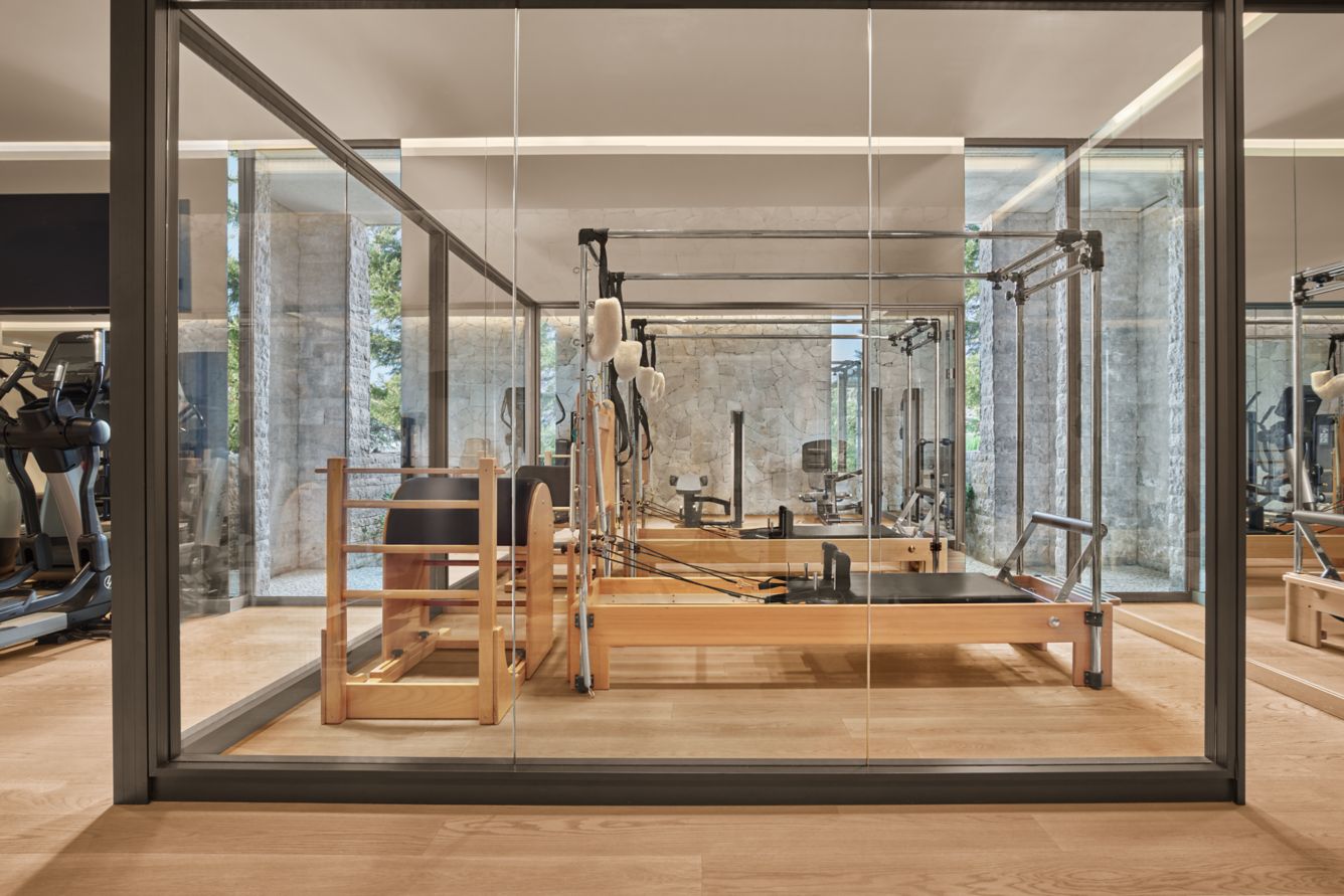 The Pilates studio — glass-walled reformer room within the gym complex