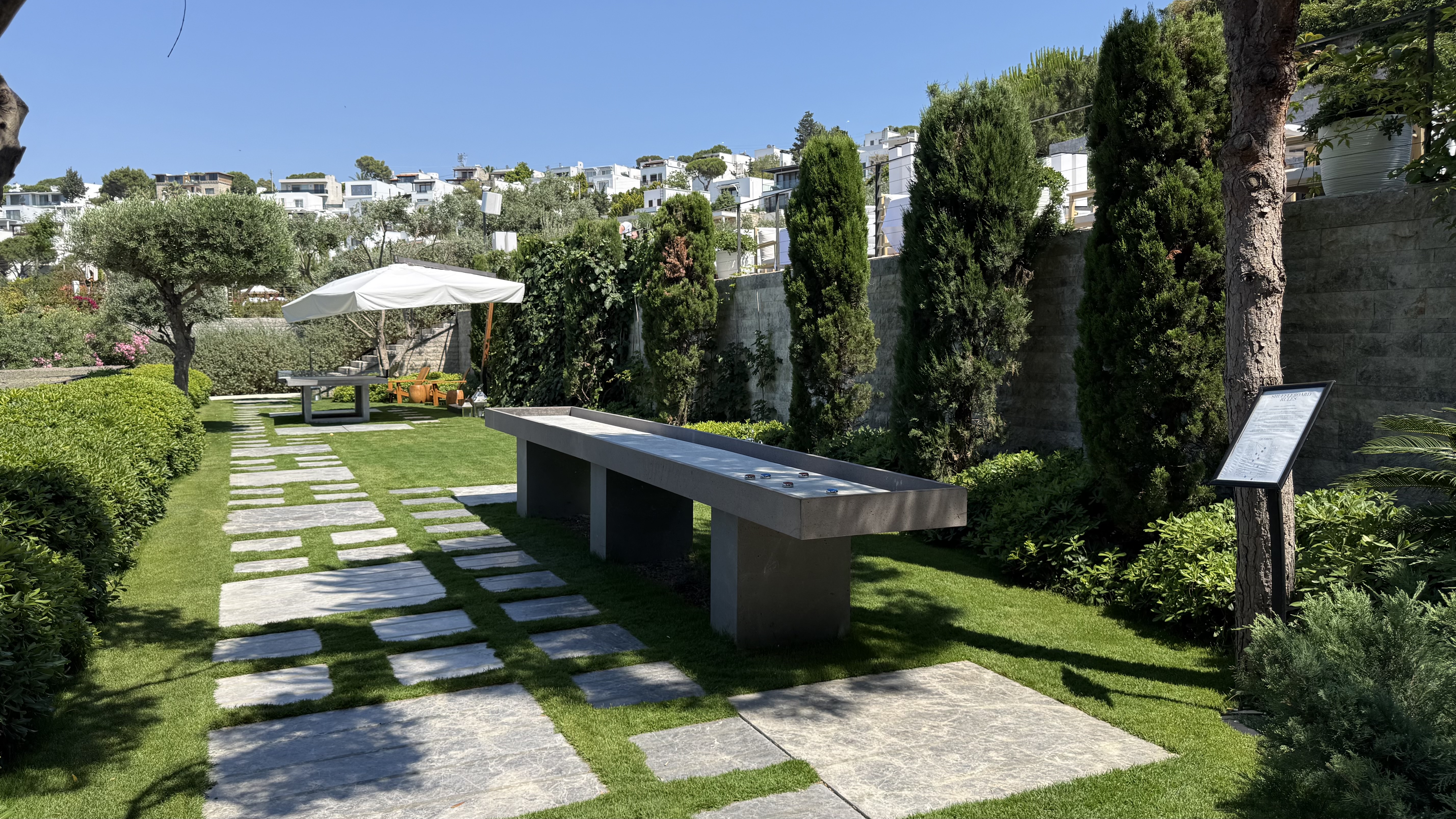 The garden grounds — shuffleboard table set among the manicured gardens and cypress trees
