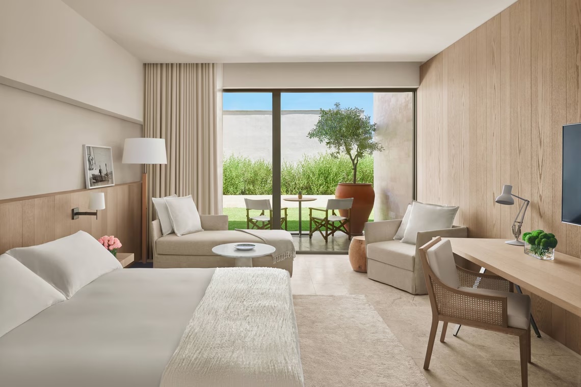 Deluxe Garden View Room in daylight — terrace with olive tree, sofa seating area and full garden view