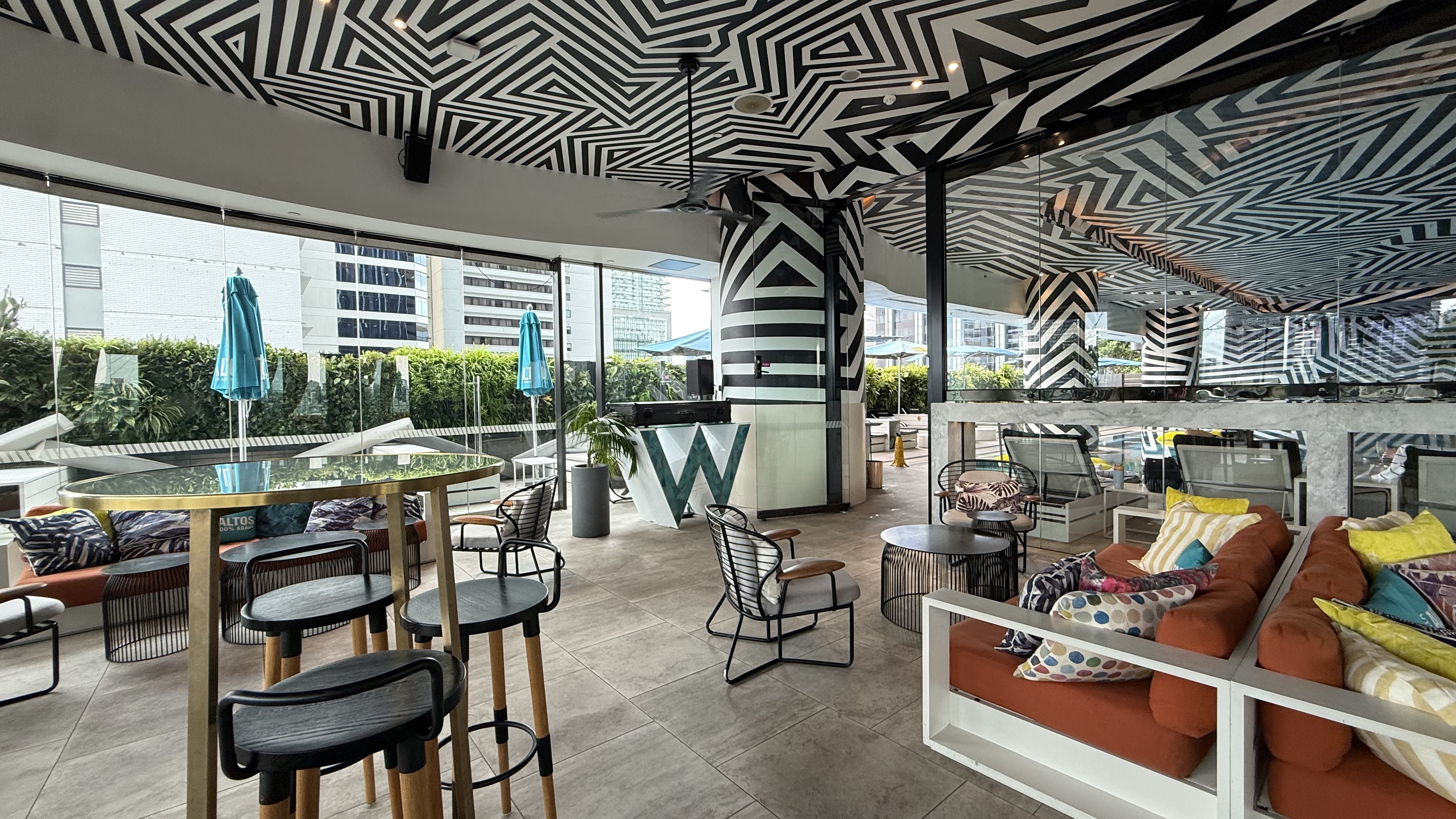 The WET Deck bar interior — B&W ceiling, W signage and open city views