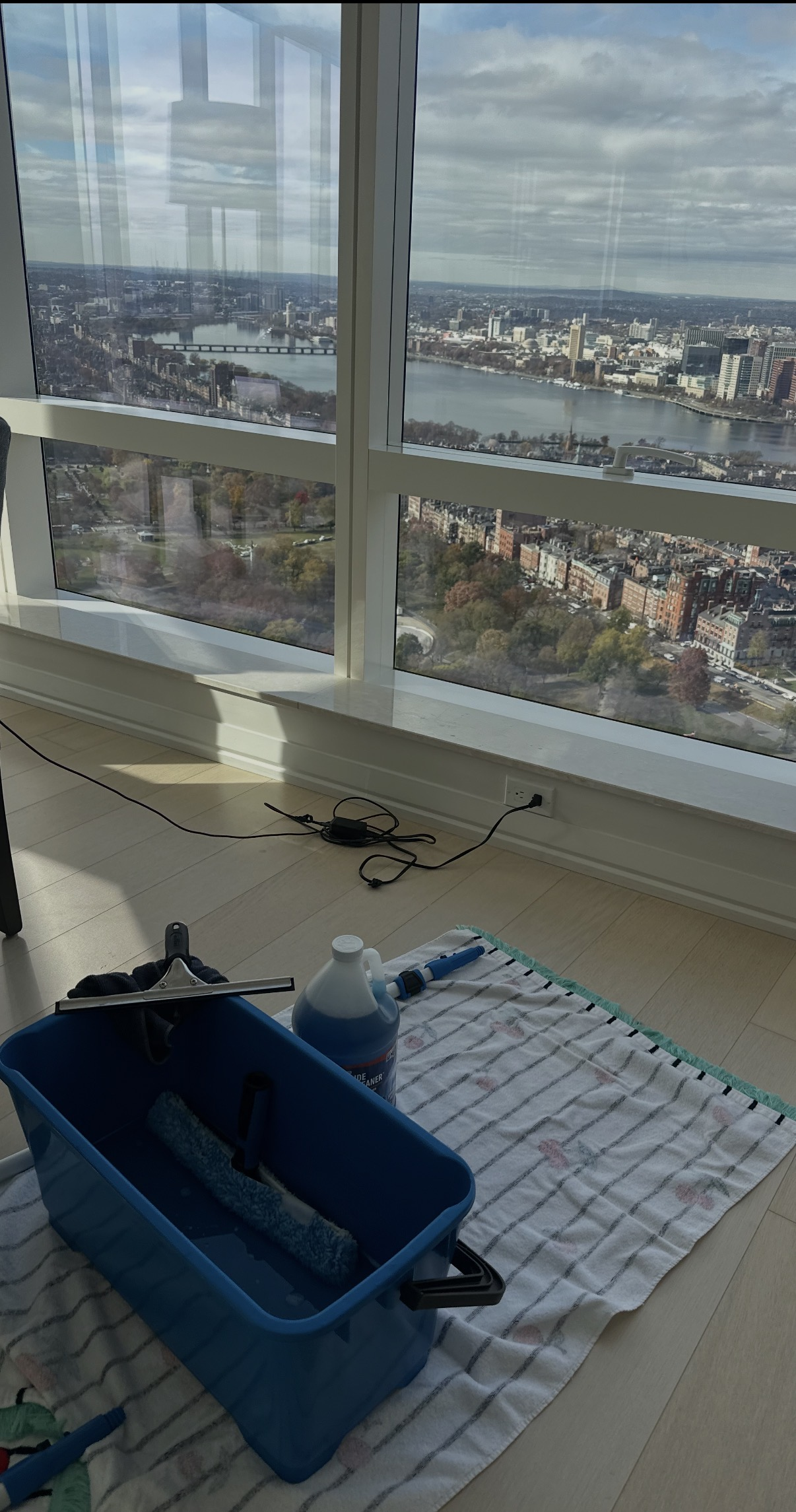 Floor-to-ceiling windows framing the Boston skyline and Charles River