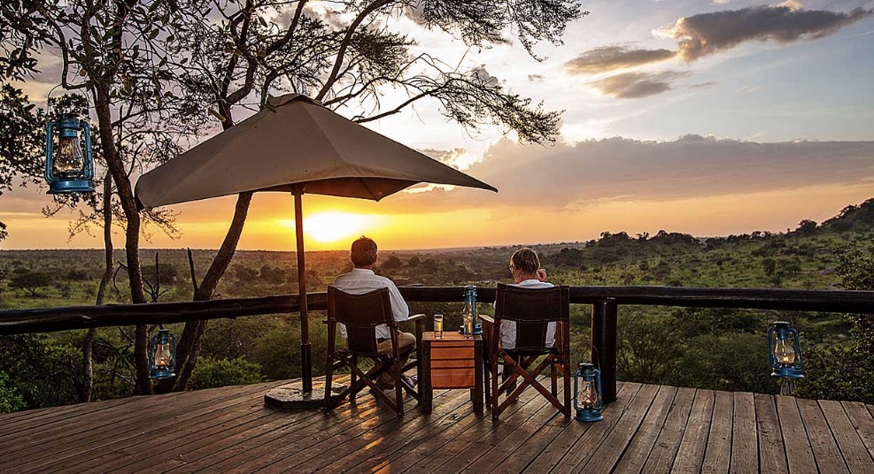 Safari sundowner on a wooden deck at sunset in East Africa