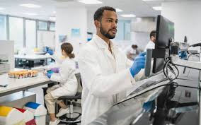 Laboratory technician processing samples with a Uganda national health lab digital system