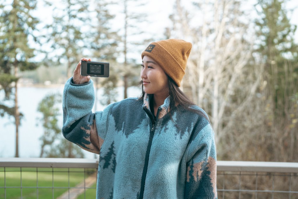 Woman holding Travel WiFi device outdoors