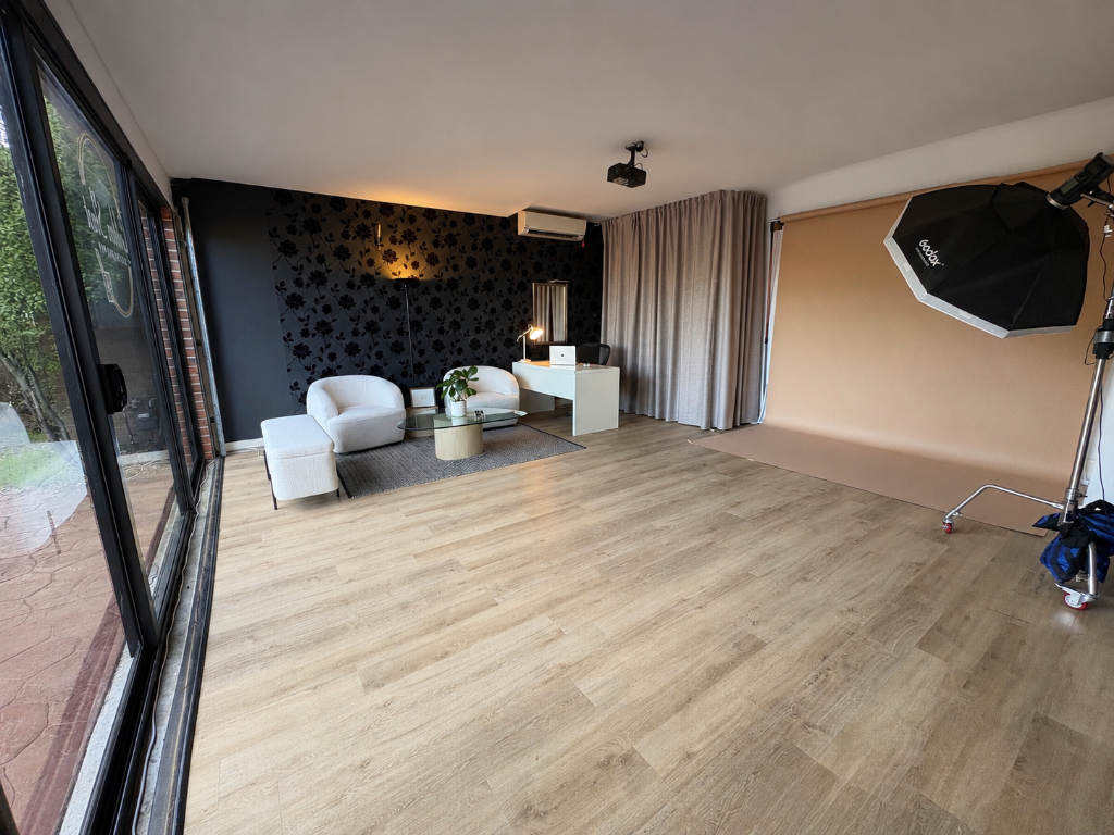 Studio interior with backdrop, lighting setup, and styled lounge area