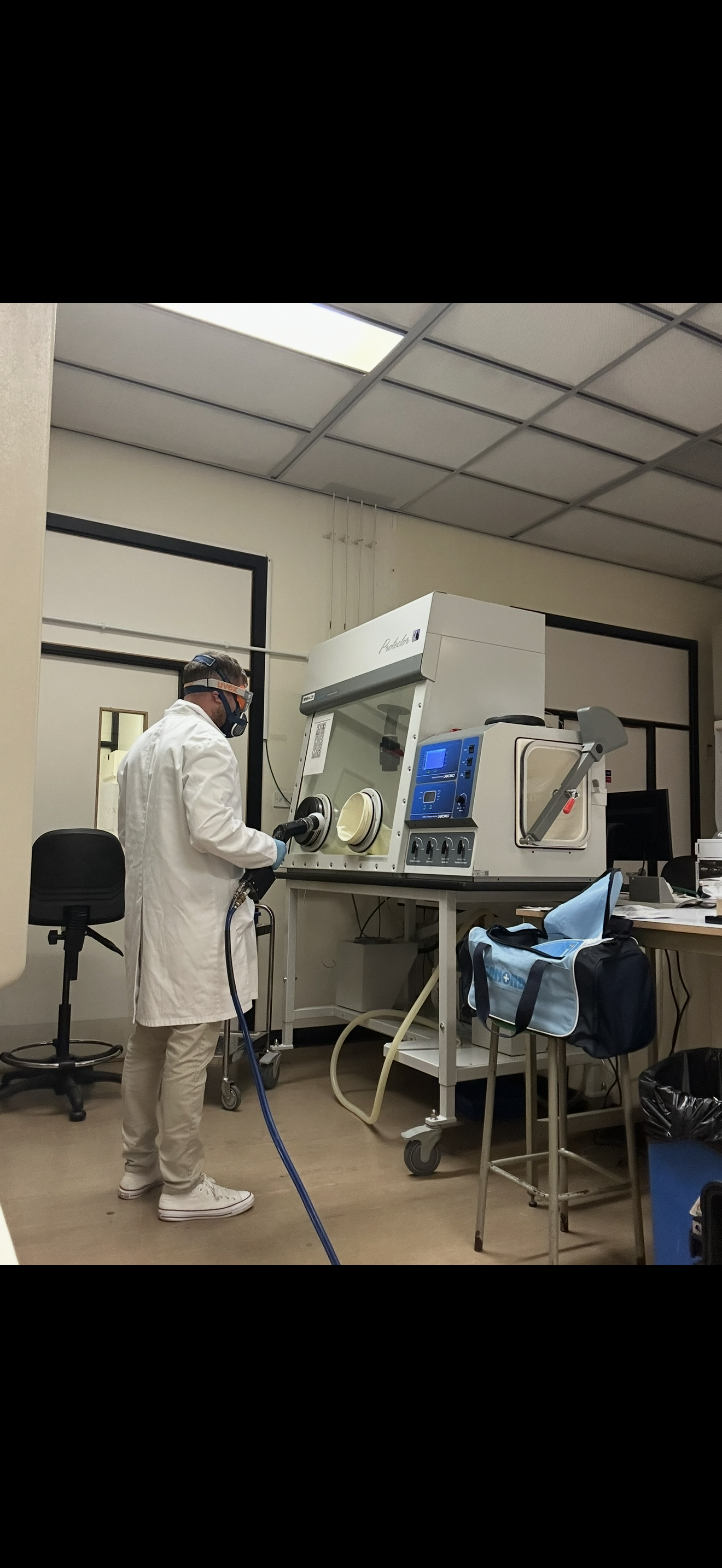 Specialist laboratory decontamination technician performing touchless disinfection in a life sciences laboratory
