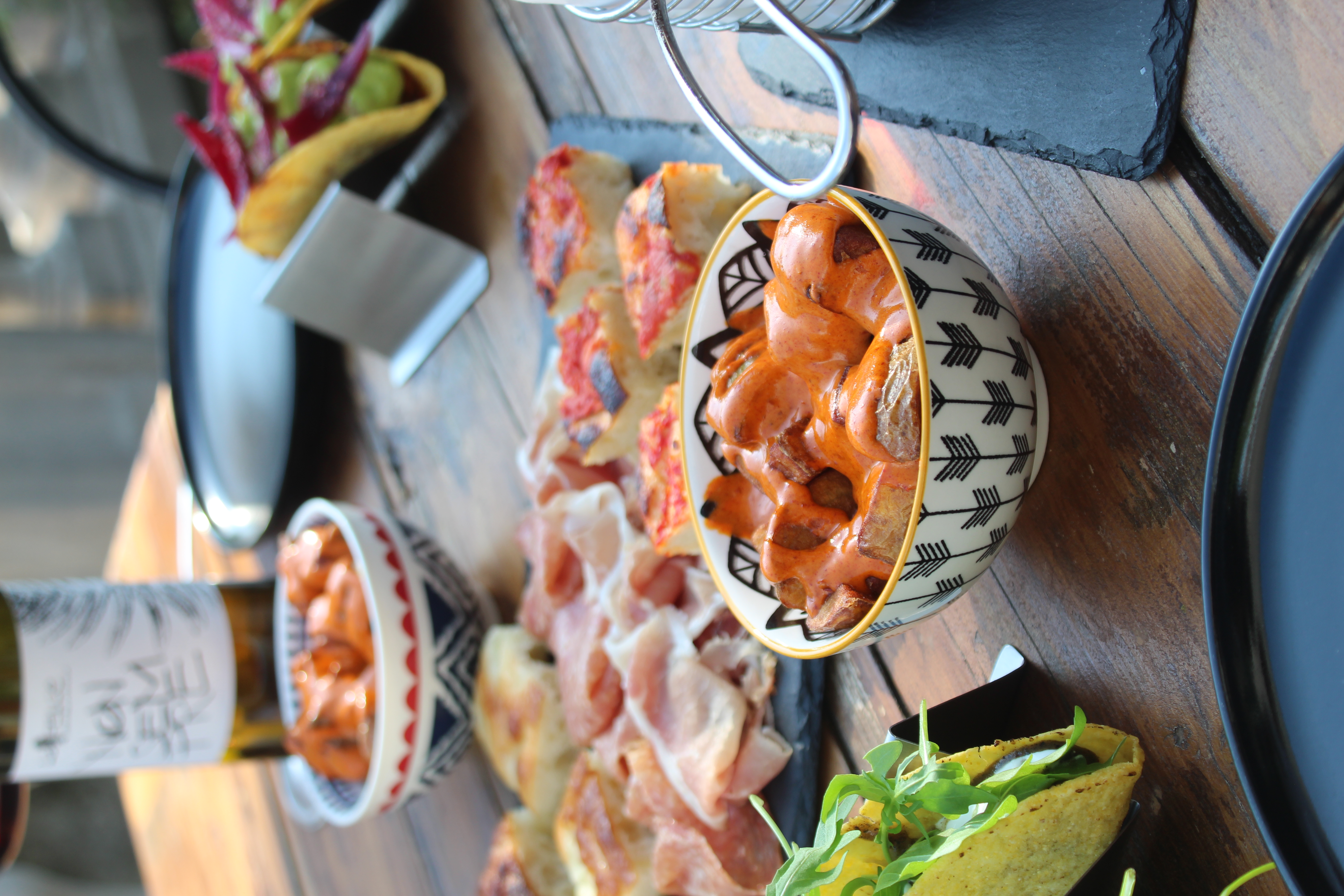 Hands clinking wine glasses over aperitivo spread