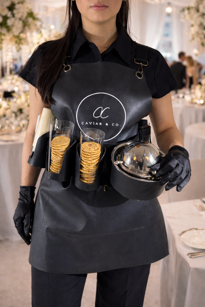 Server wearing bespoke caviar serving belt at an elegant event