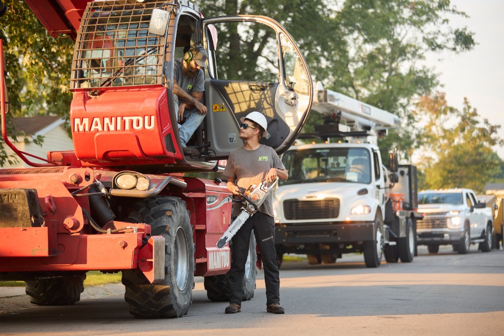 NPS crew member with chainsaw next to Manitou equipment