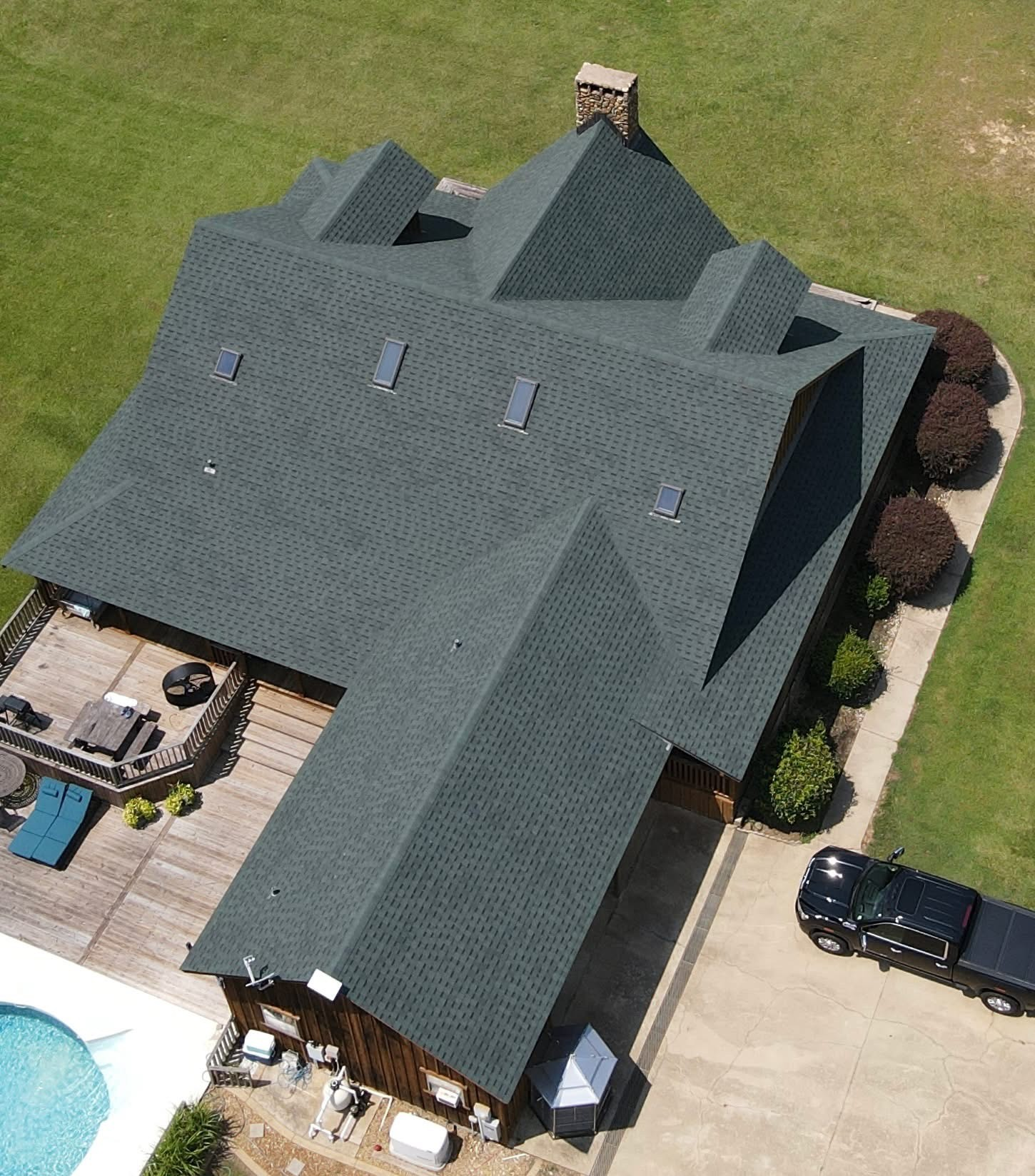 Completed log cabin roof with skylights and stone chimney