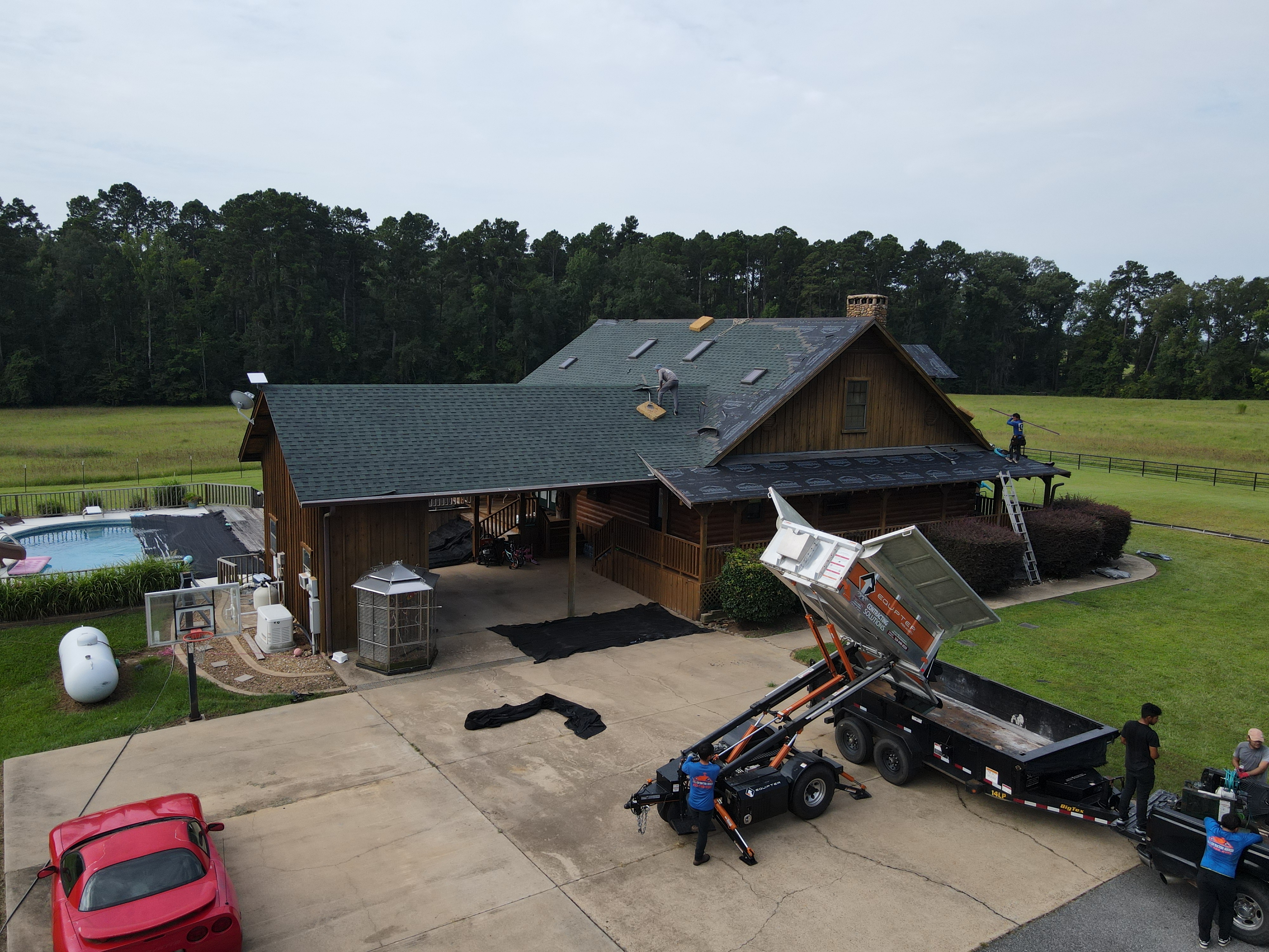 Aerial view of the log cabin home with roof sections under repair
