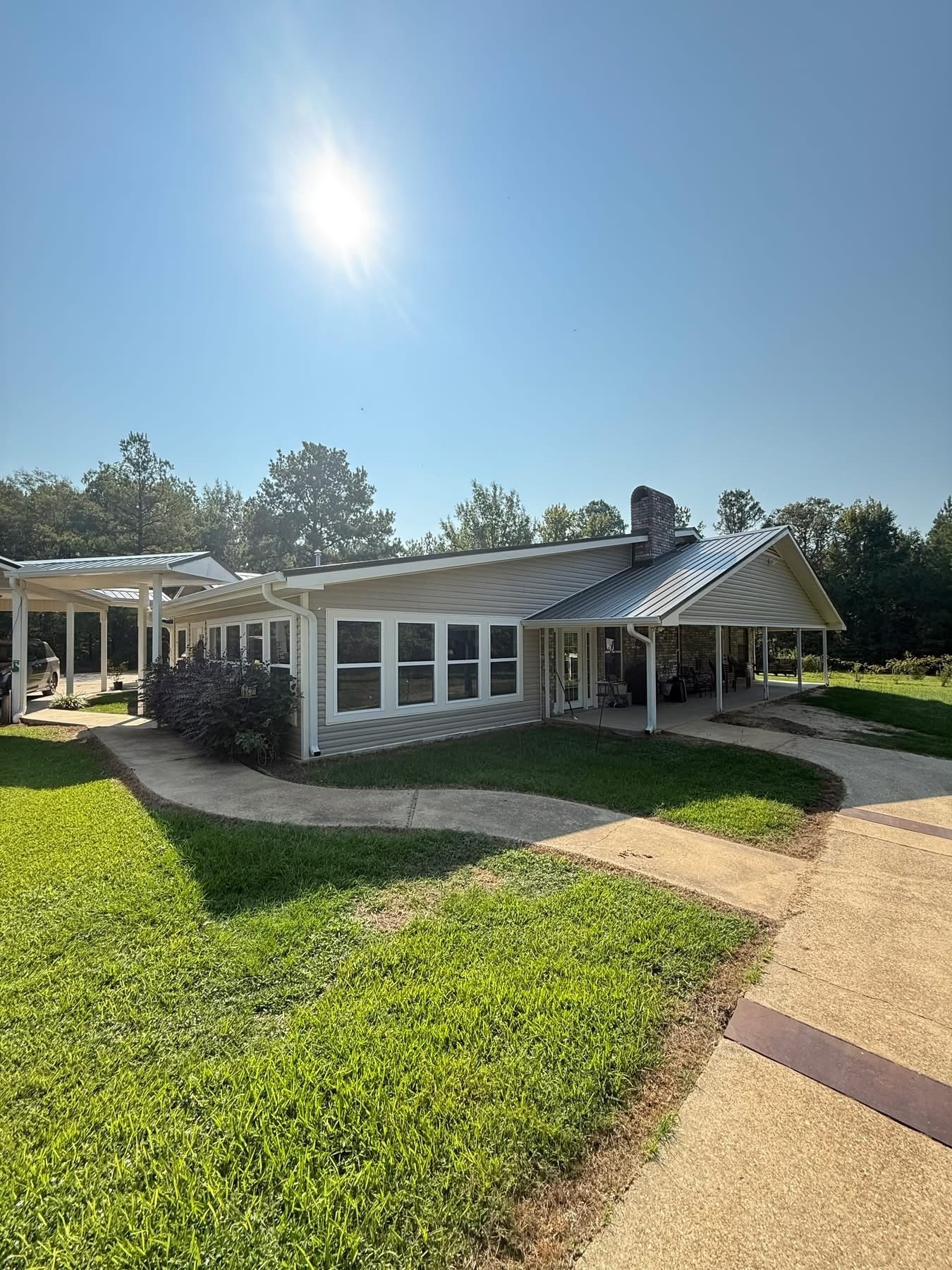 Ranch home with finished standing-seam metal roof and stone chimney