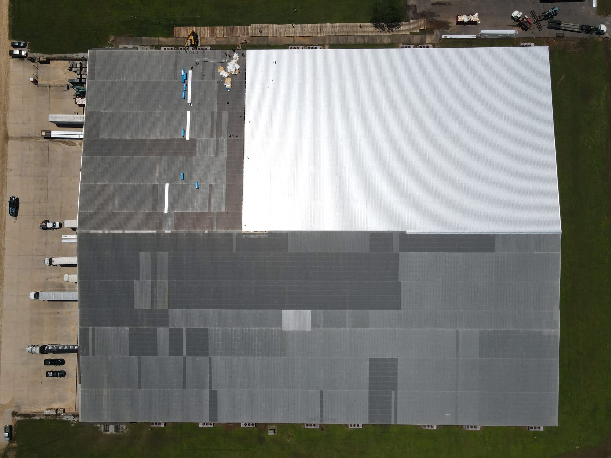 Top-down of commercial roof a quarter re-sheeted with reflective metal