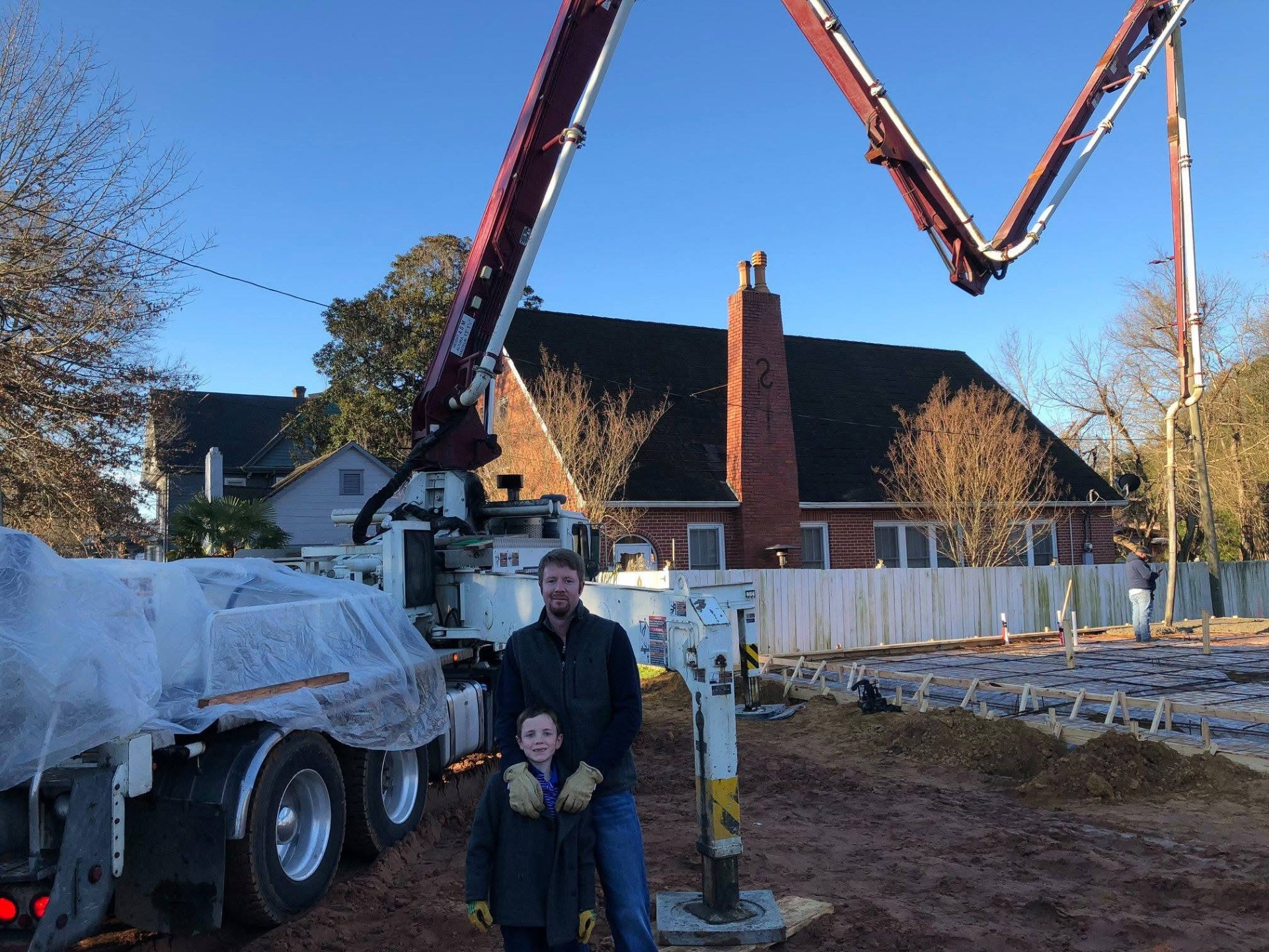 Concrete pump truck pouring a residential foundation with formed rebar grid