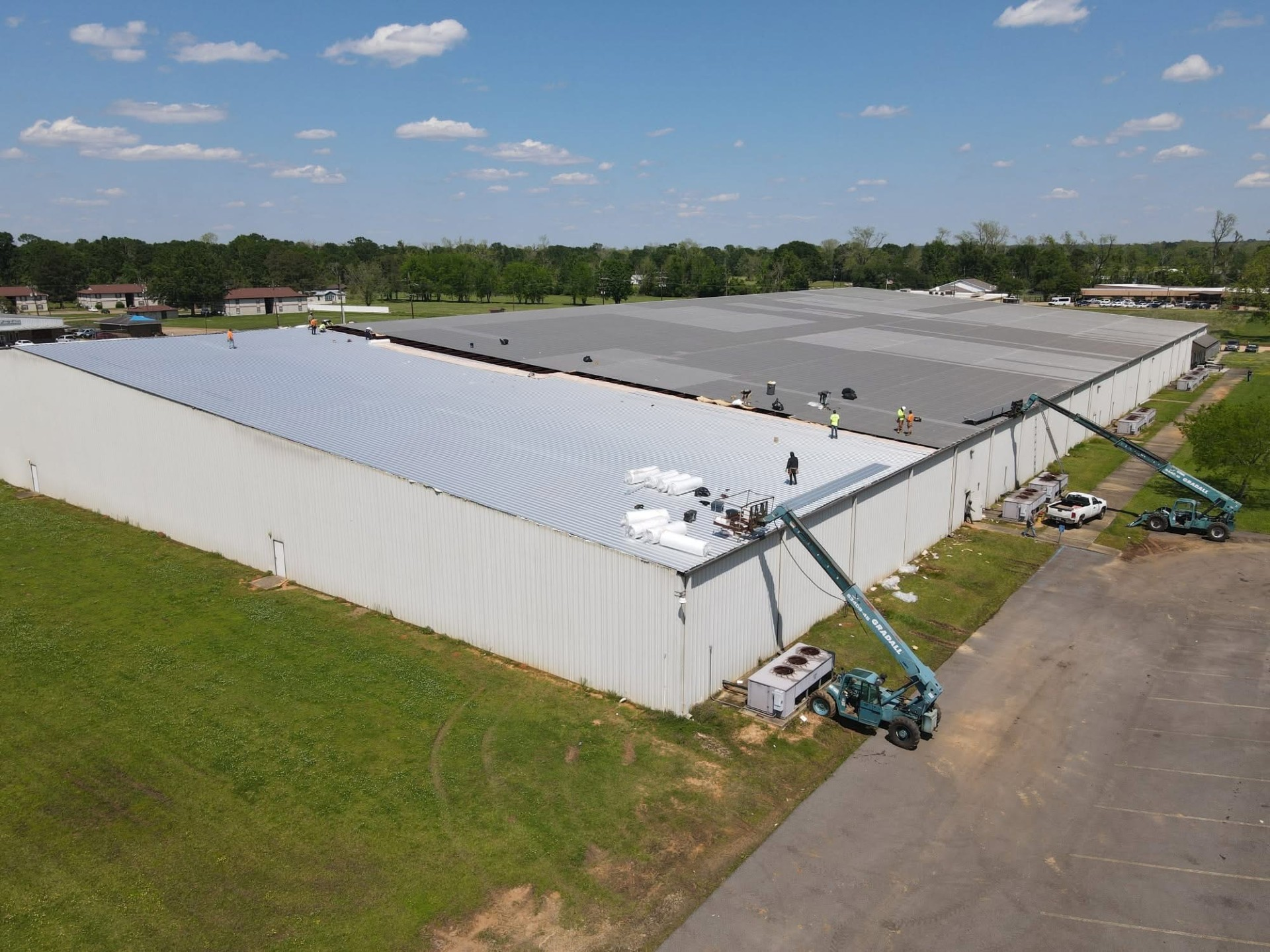 GRADALL telehandler feeding material to the roofline during commercial re-roof