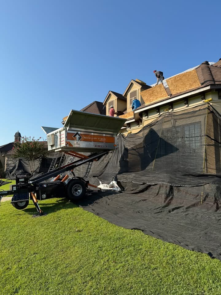 Crew stripping shingles on a multi-story home with Equipter catching debris
