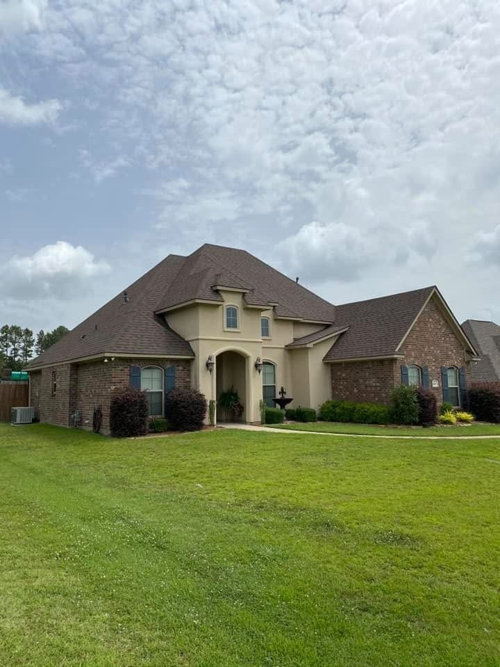 Single-story stucco and brick home with arched entry and fountain