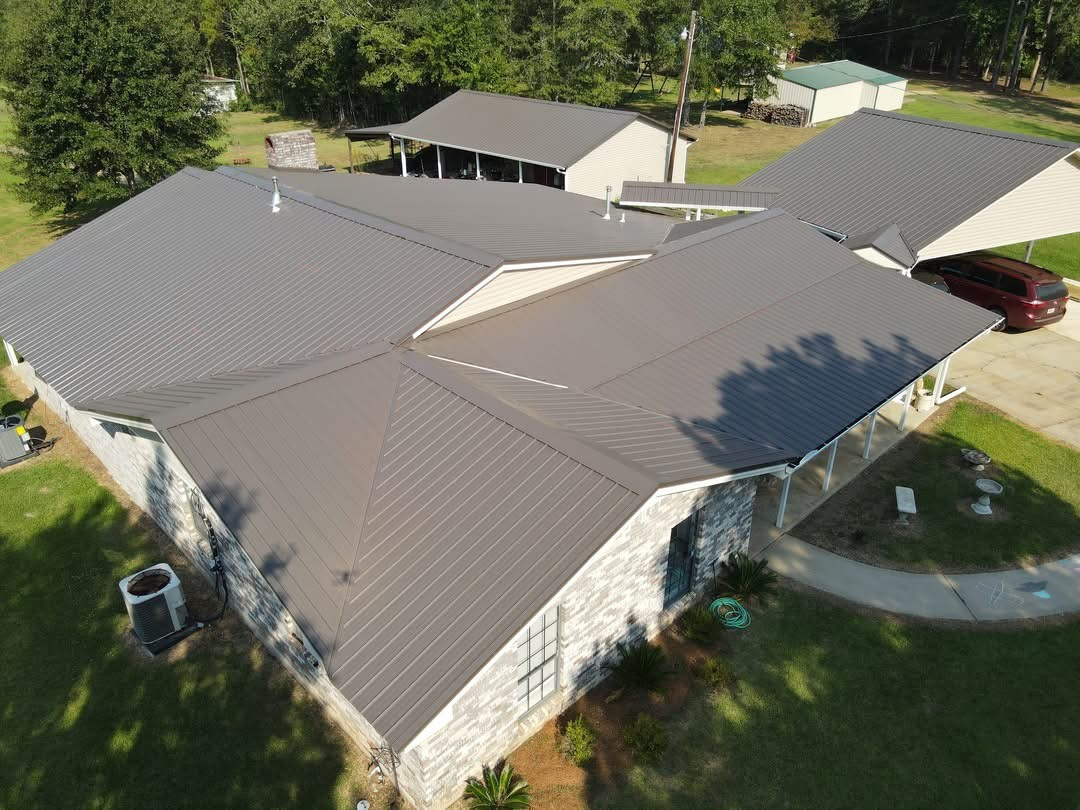 Aerial of multi-gabled home with new dark metallic standing-seam roof