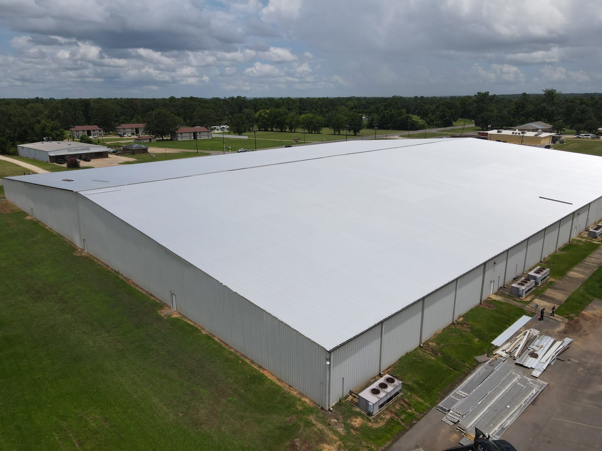 Warehouse re-roof in progress — new white panels meeting the old dark section