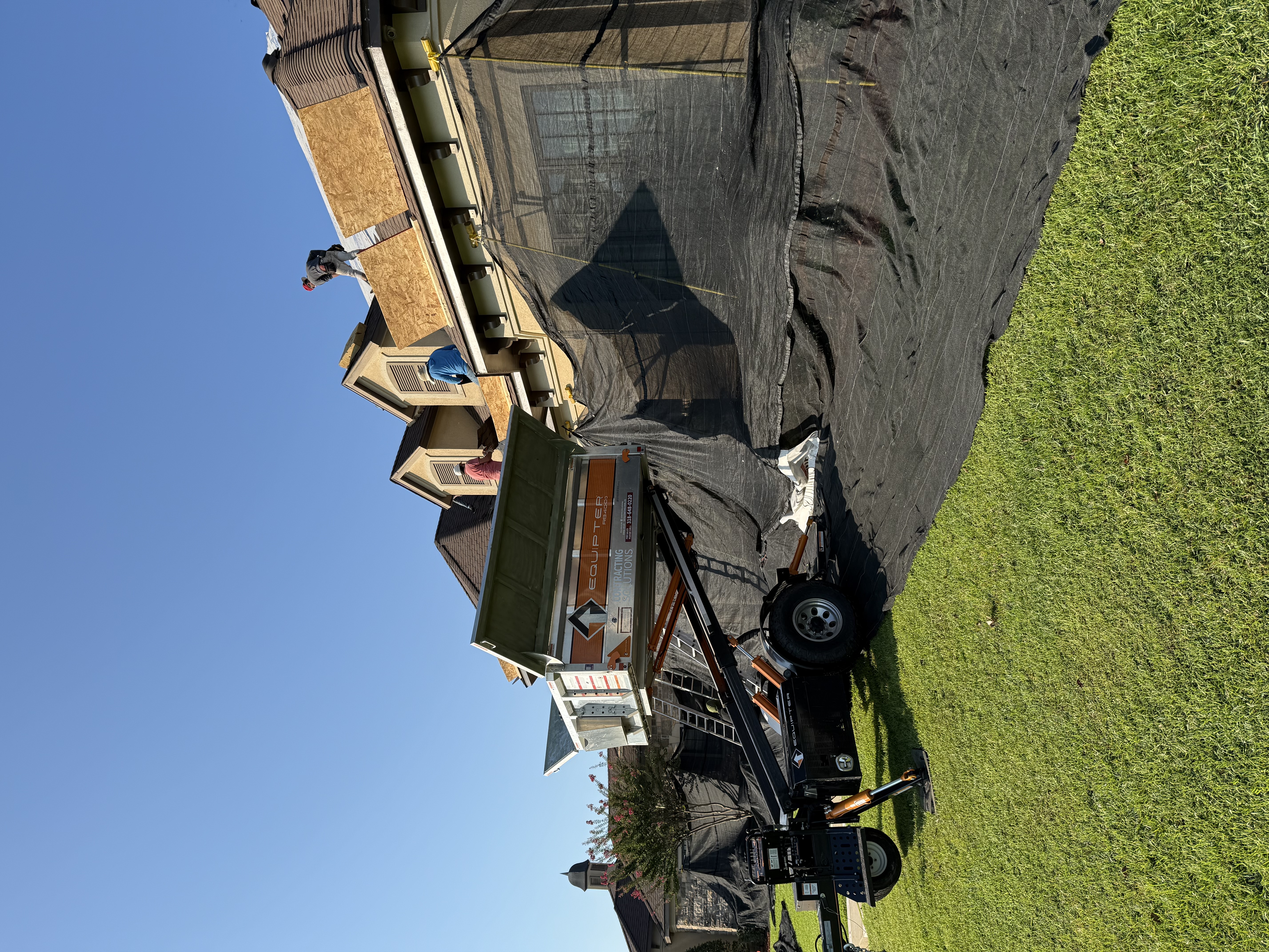 Equipter positioned beneath the roofline with protective mesh netting