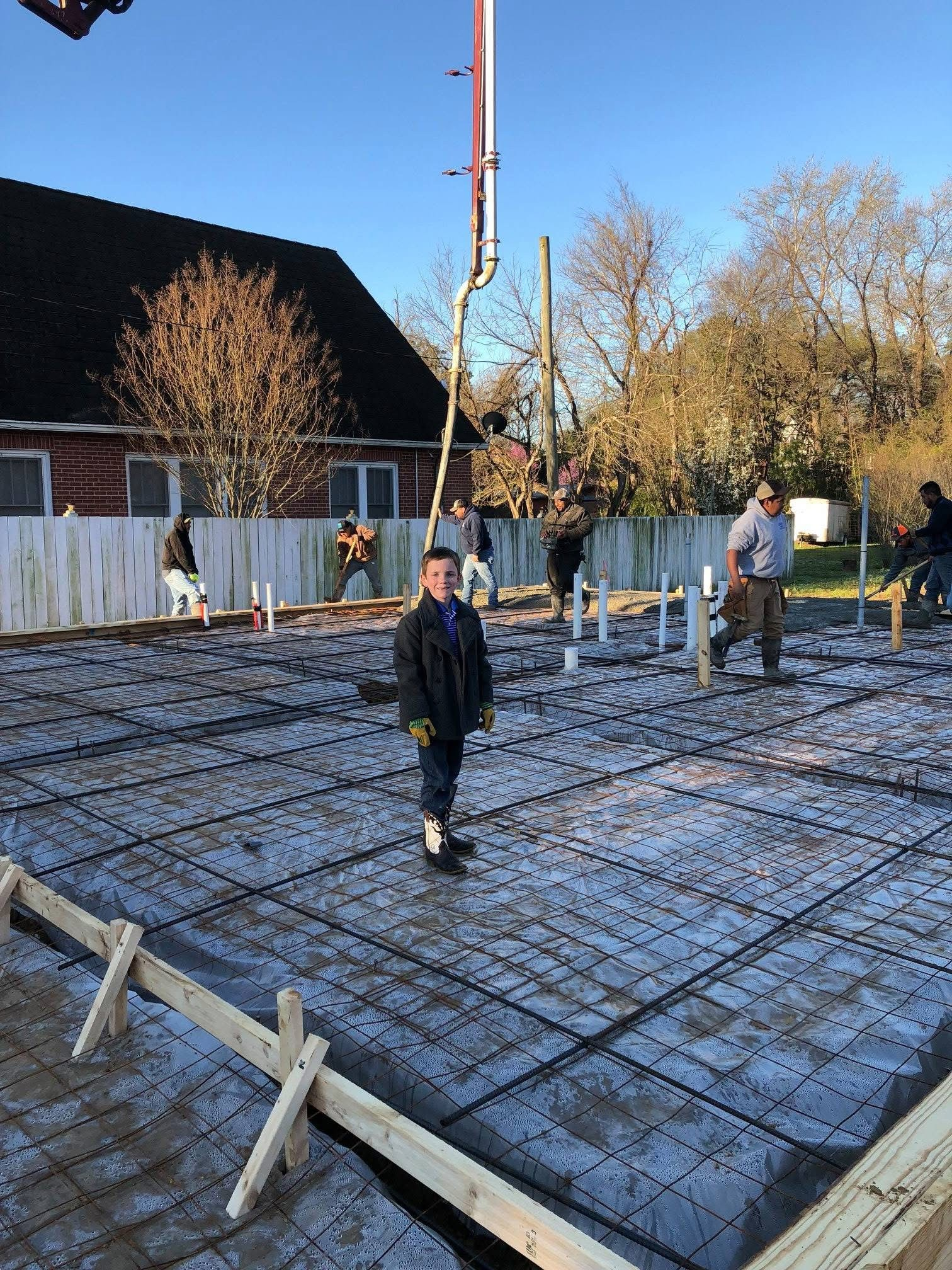 Residential slab pour with rebar mesh, vapor barrier and concrete pump truck