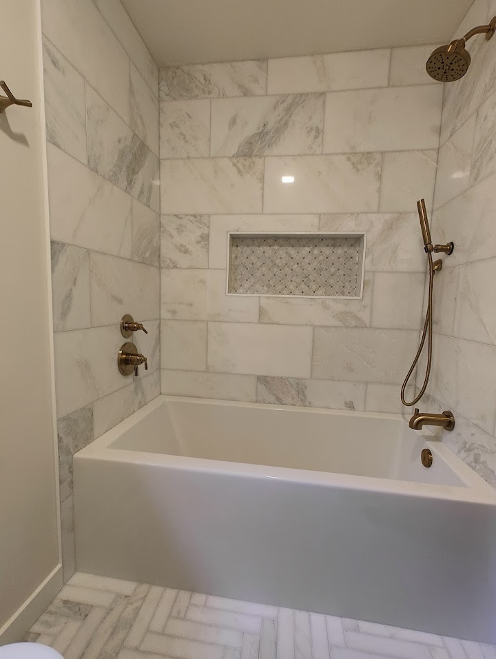 Marble Tub Surround and Herringbone Floor Bathroom Remodel Redmond WA