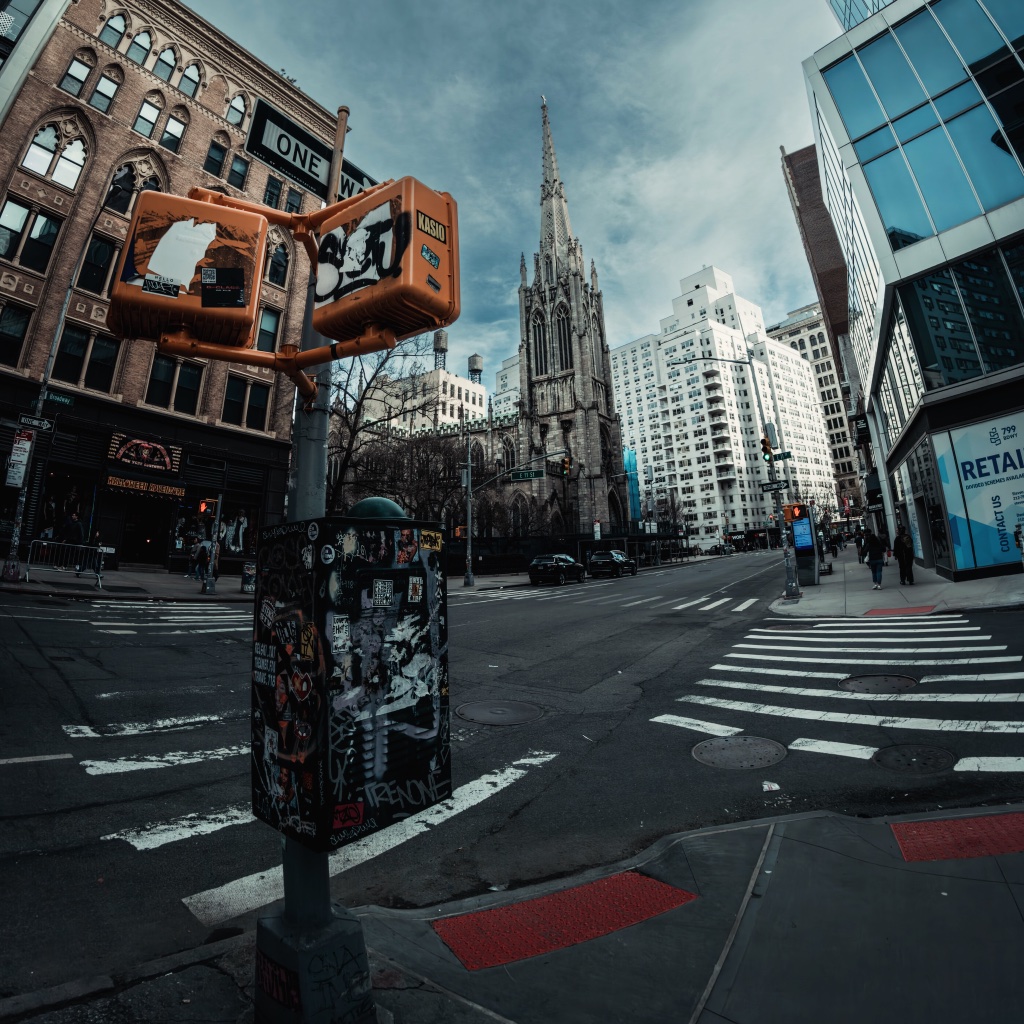 NYC street intersection with church spire and urban architecture
