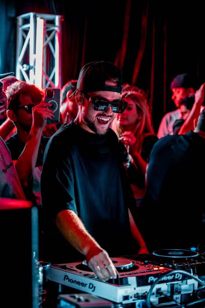 DJ smiling behind Pioneer DJ decks at live event