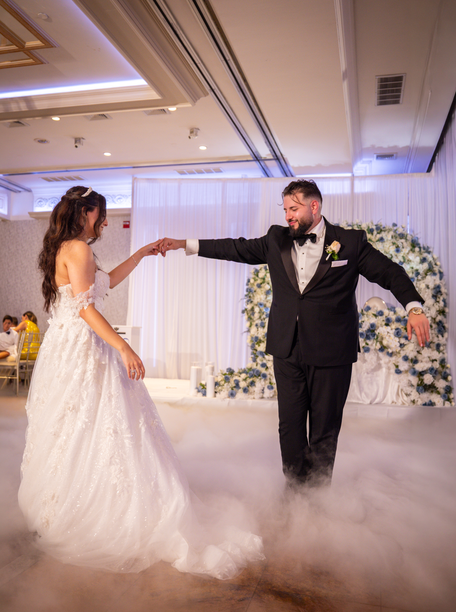 Bride and groom dancing on a fog-covered dance floor at their wedding reception