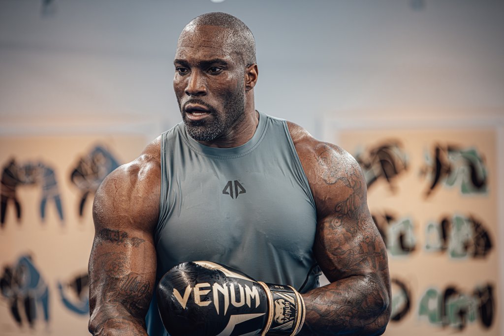 Muscular boxer with Venum gloves in gym setting