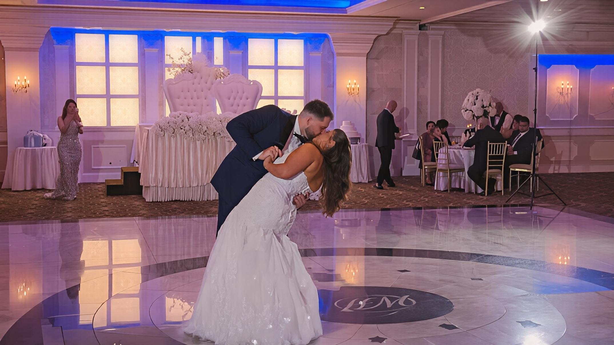 Groom dipping bride in a kiss on the dance floor at a ballroom wedding