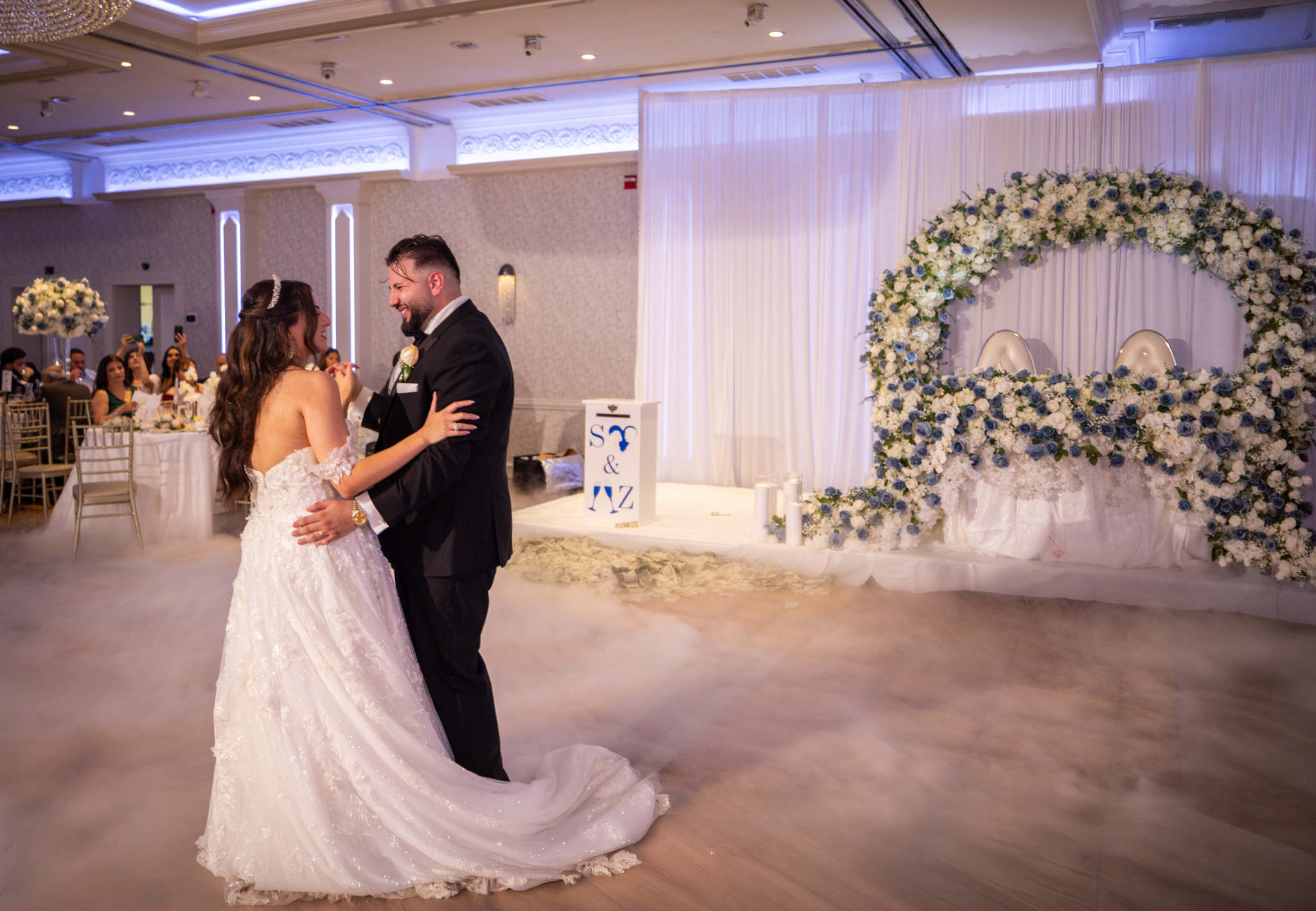Bride and groom dancing at their wedding reception with a card box in the foreground