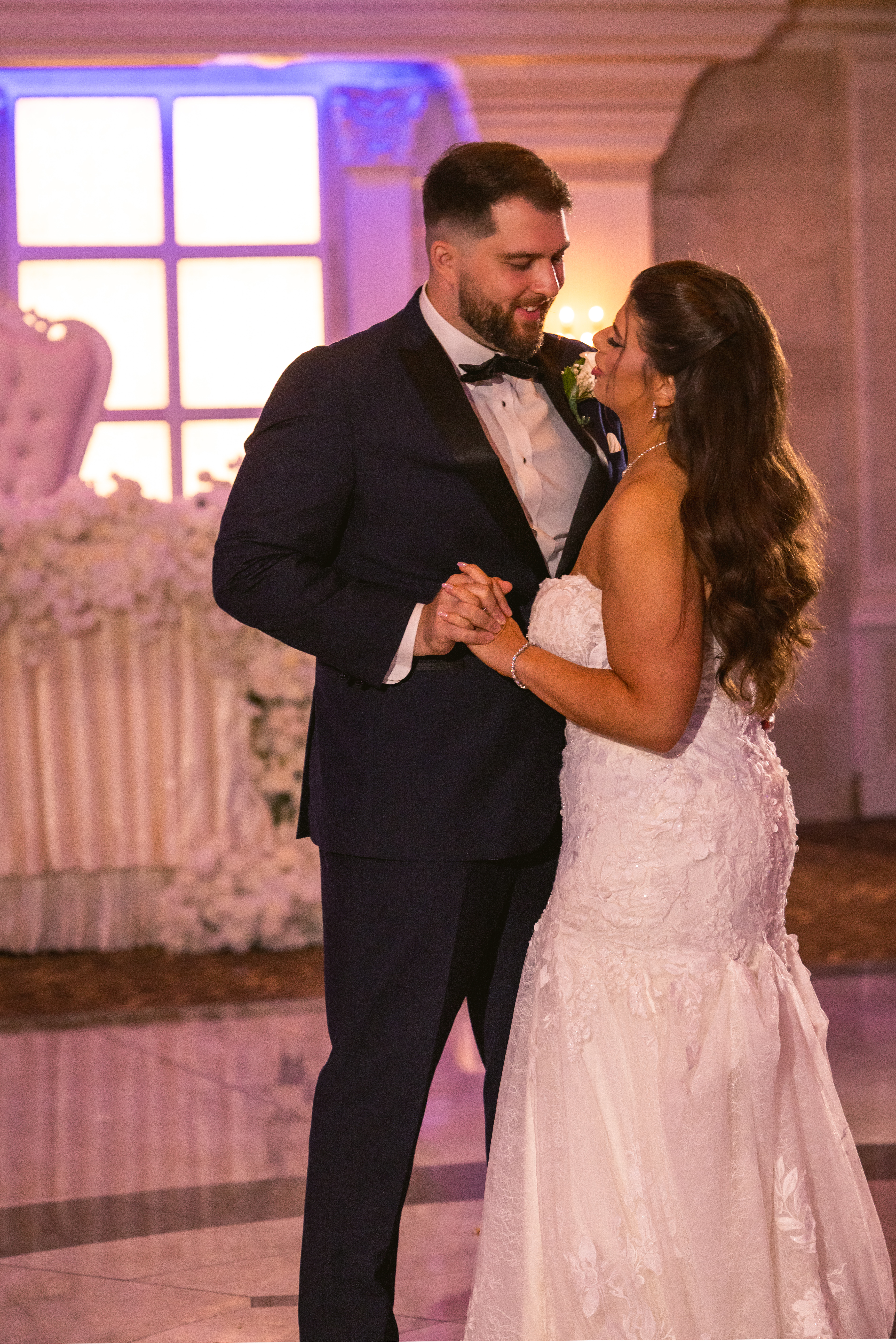 Bride and groom holding hands while dancing at their wedding reception