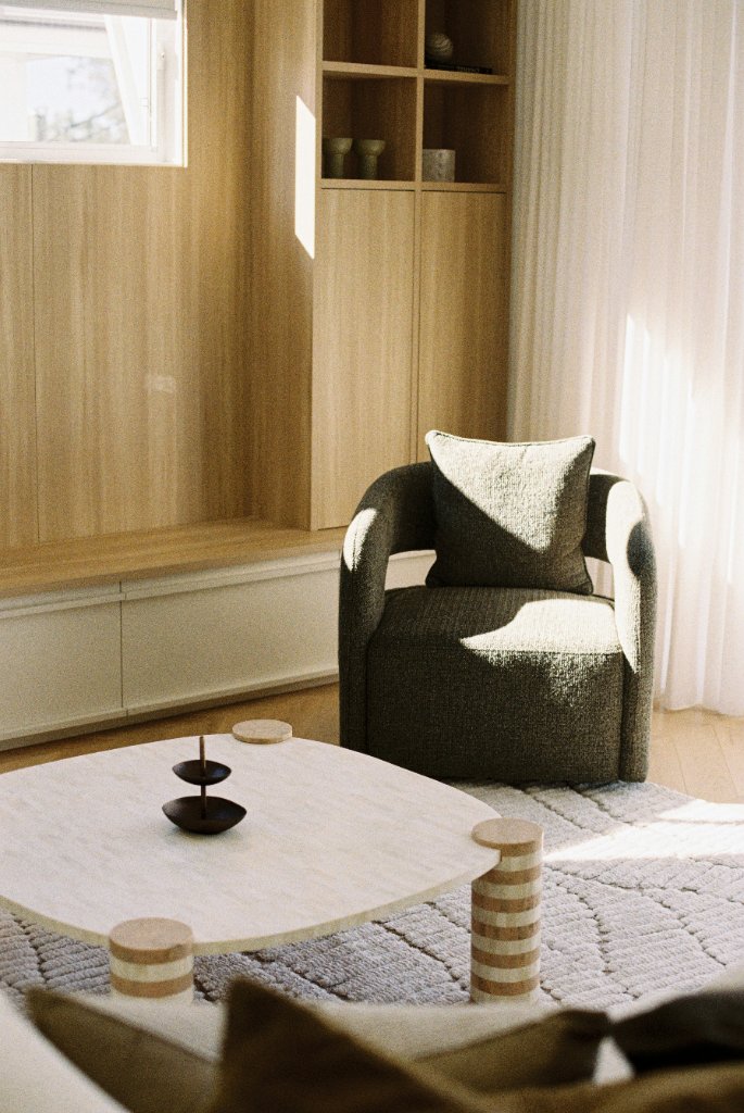 Elegant living room with armchair and timber cabinetry