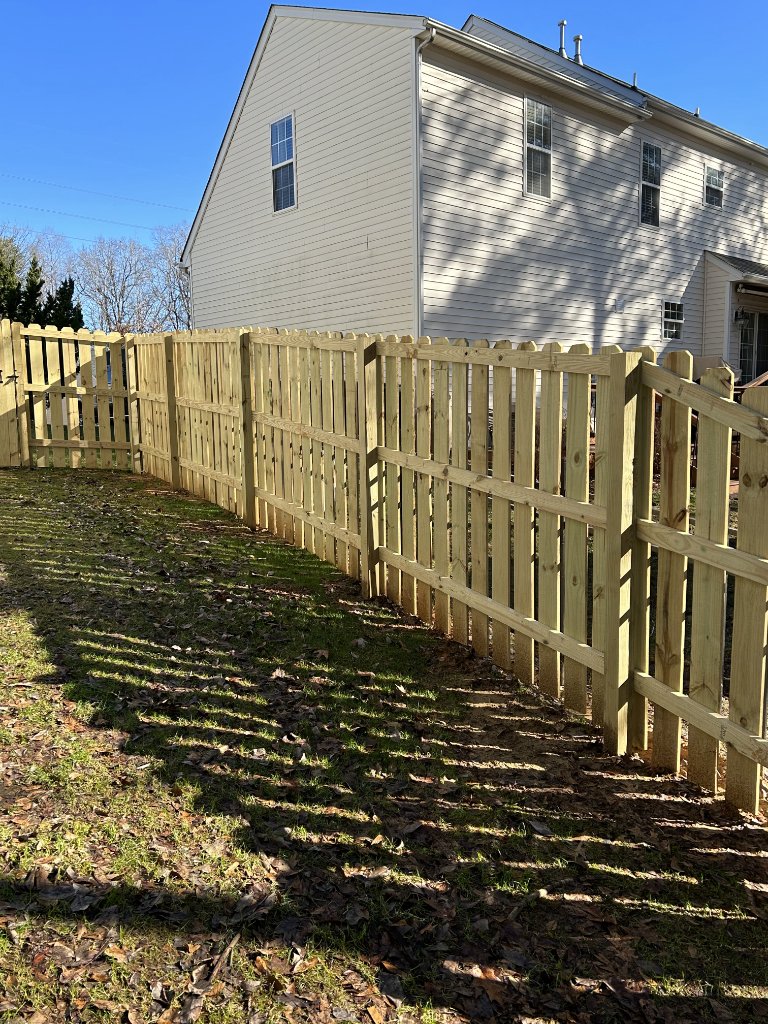 Spaced picket fence on slope with gate
