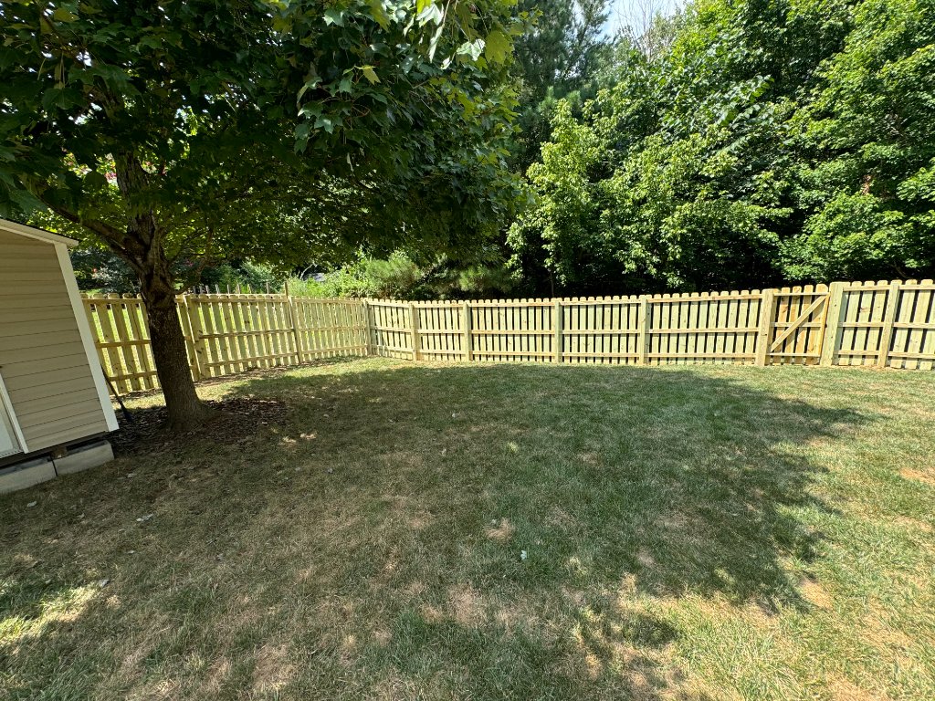 Spaced picket fence next to shed